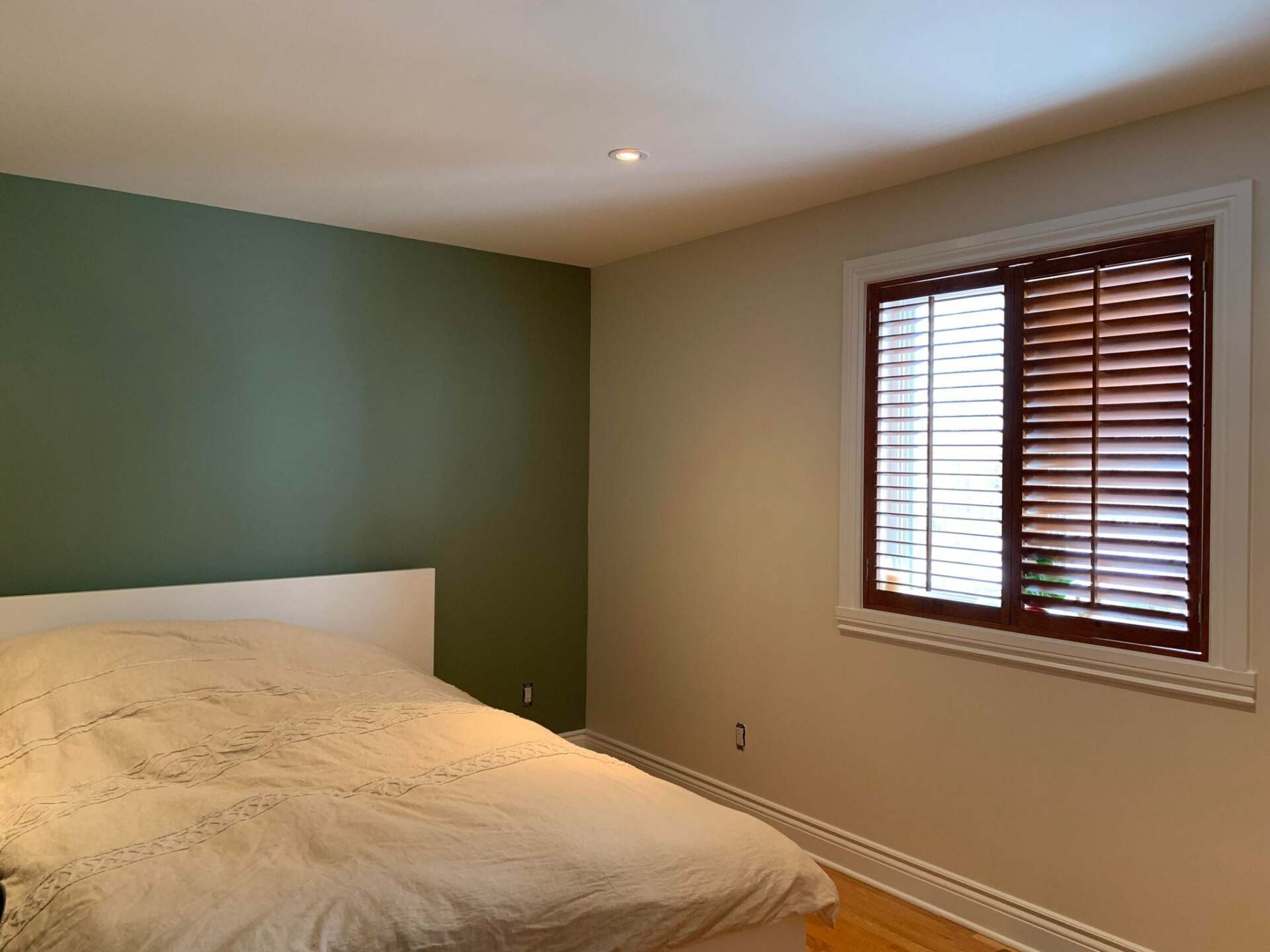 Une chambre avec un lit et une fenêtre avec stores