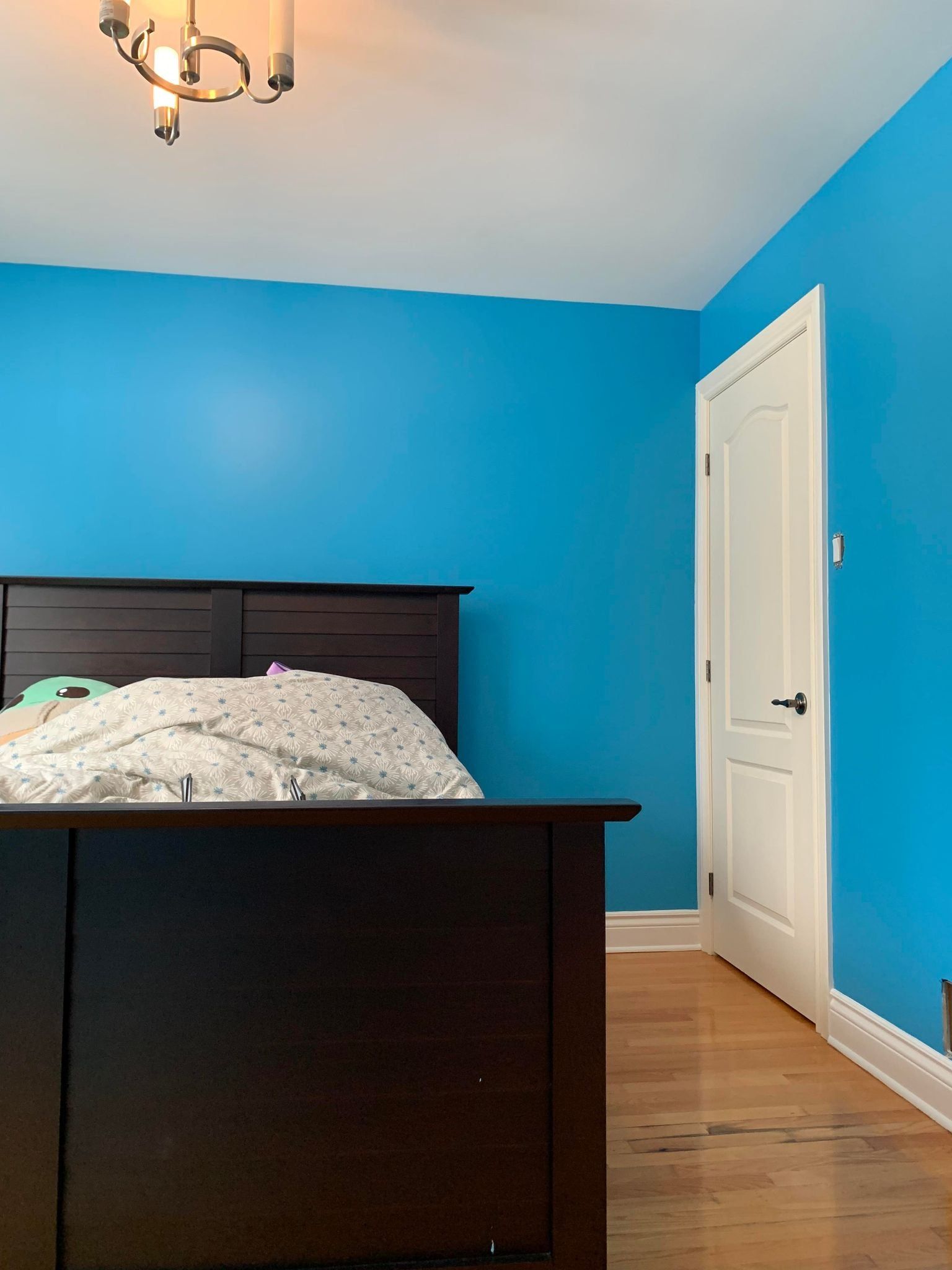 Une chambre avec des murs bleus et un lit