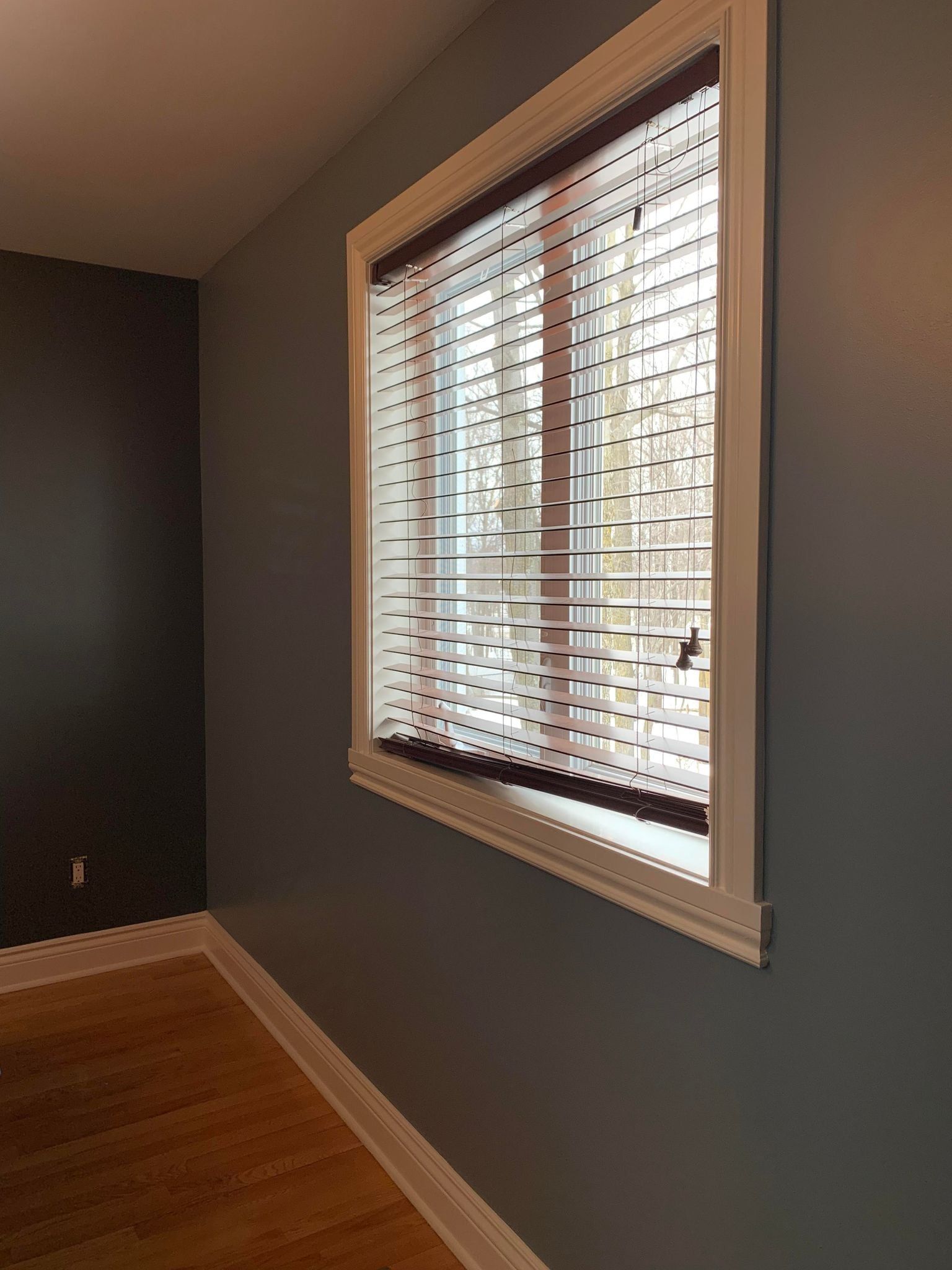 Une pièce avec une fenêtre et des stores.