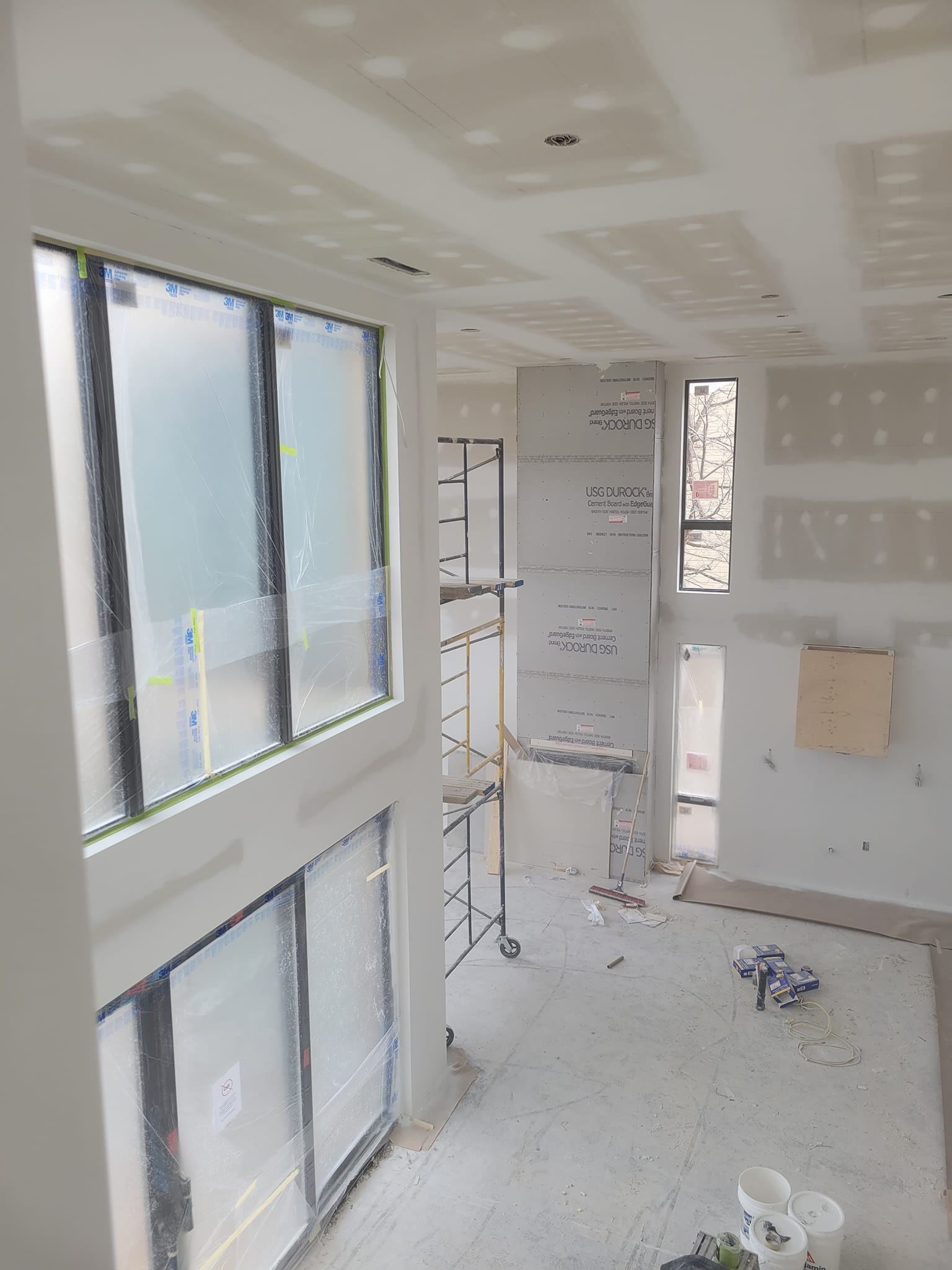 Une pièce avec beaucoup de fenêtres et d'échafaudages.