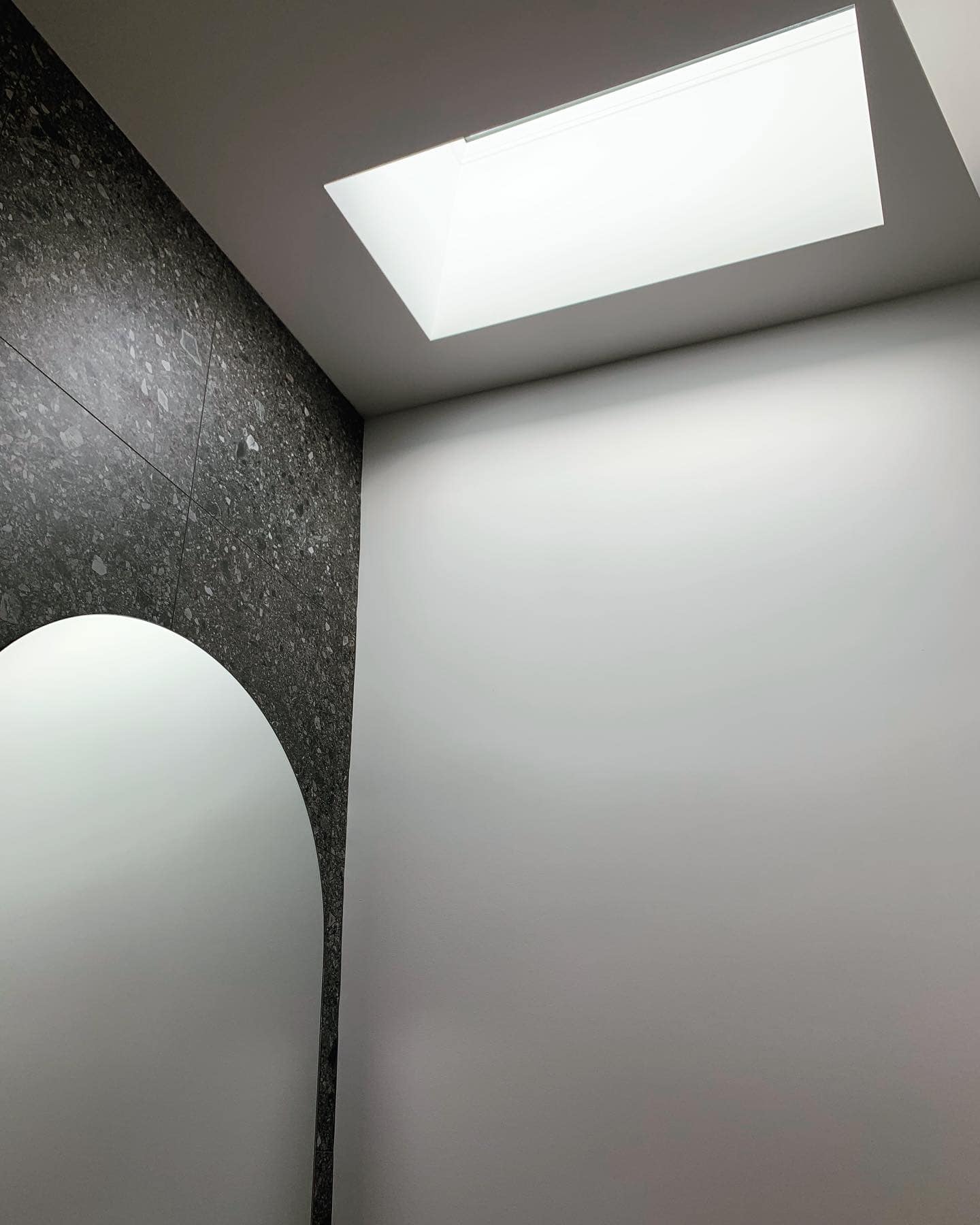 Une salle de bain avec un miroir et une lucarne au plafond
