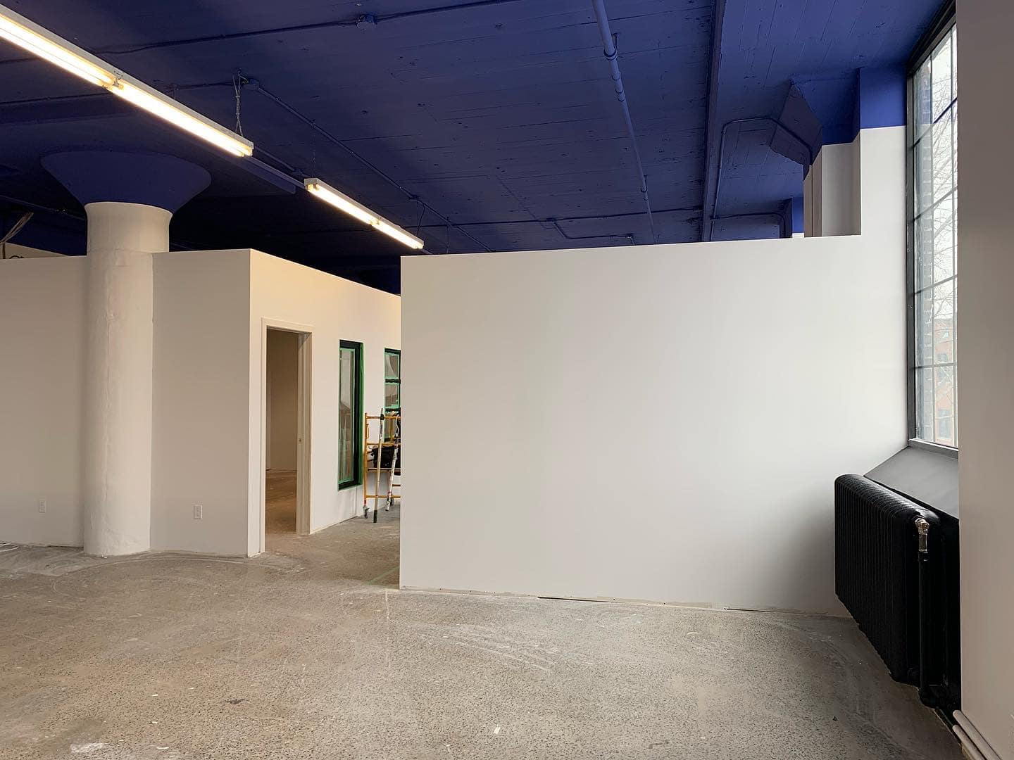 Une pièce vide avec un plafond bleu et des murs blancs