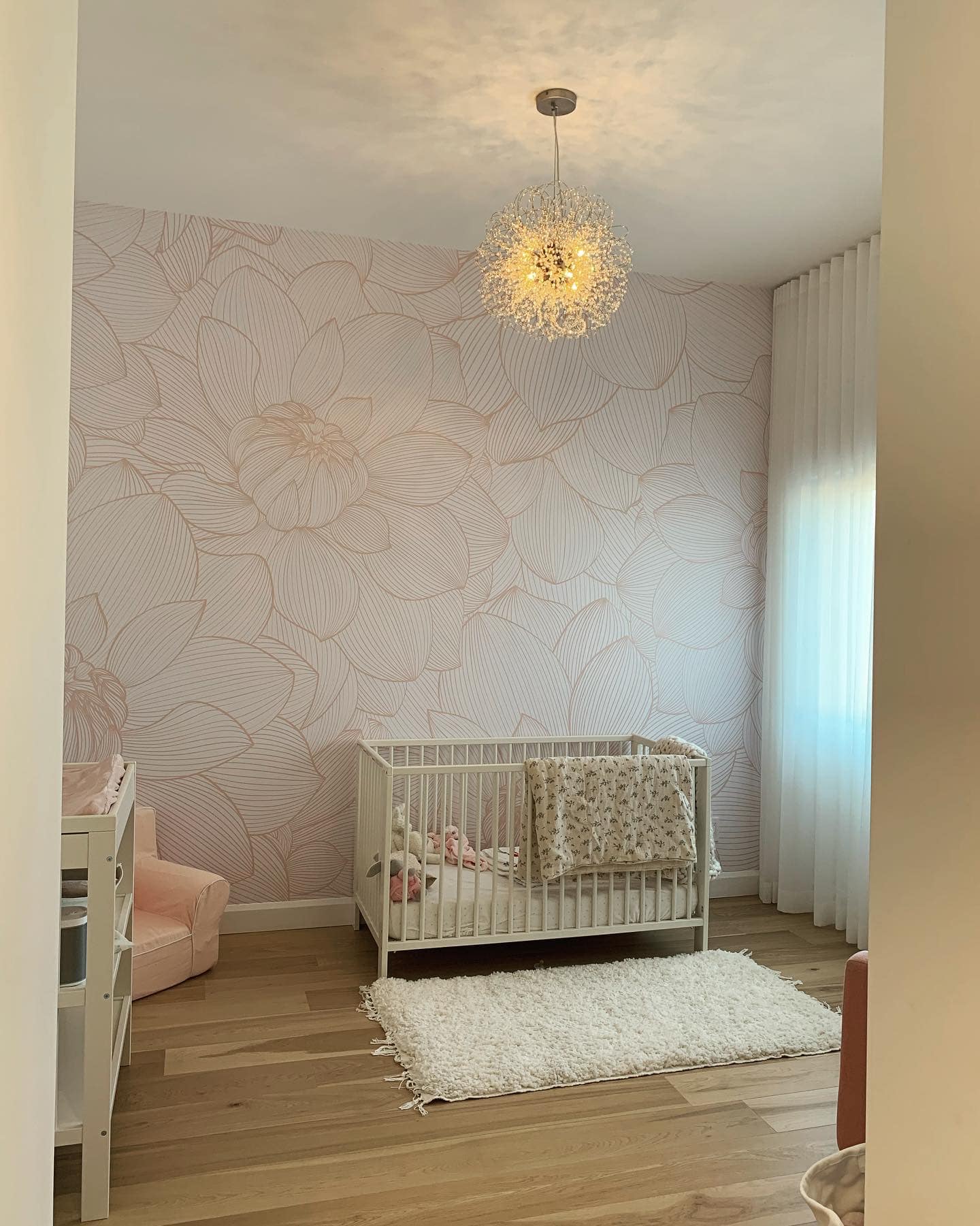 Une chambre de bébé avec un berceau et un lustre suspendu au plafond.
