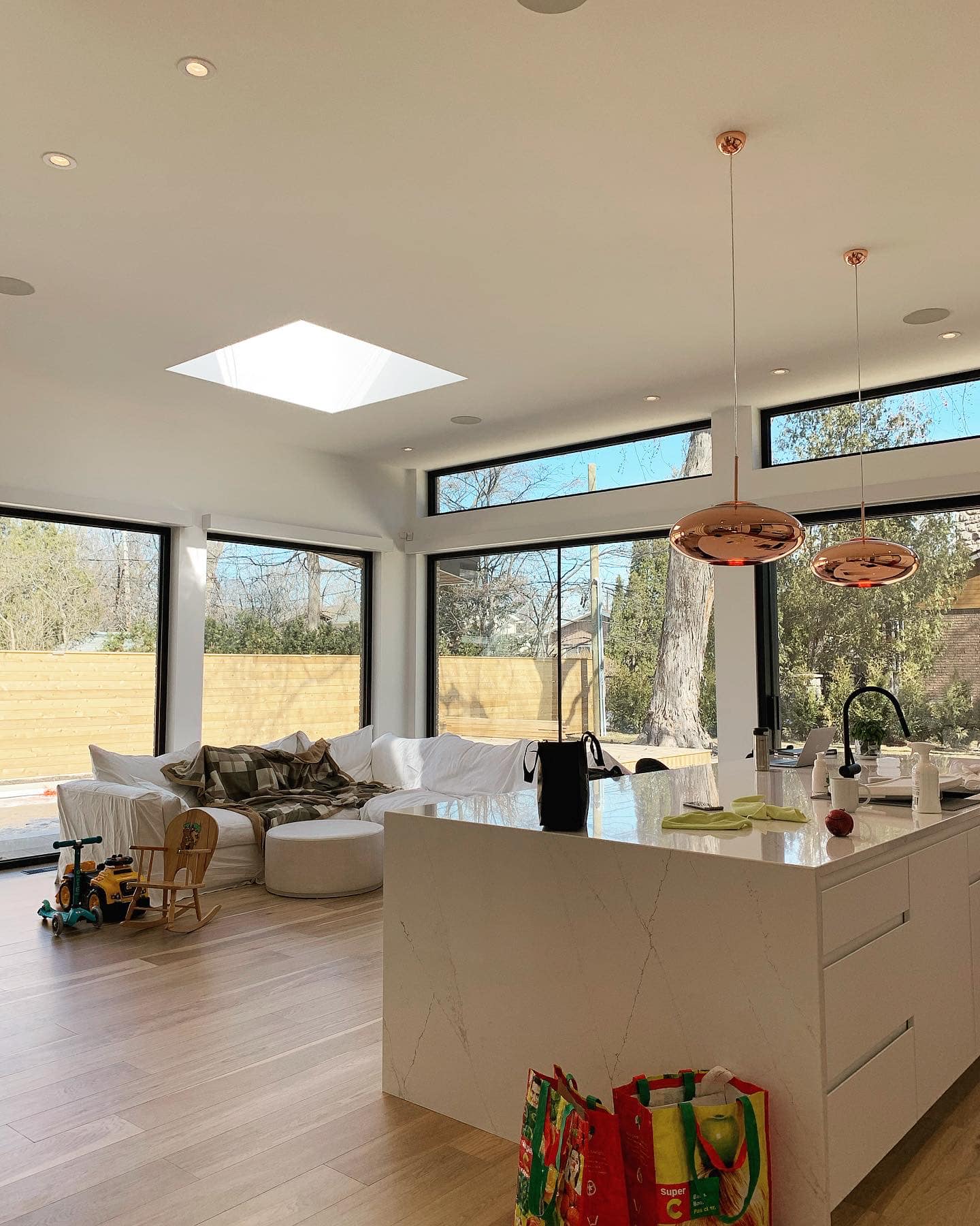 Un salon avec un canapé et une cuisine avec beaucoup de fenêtres.