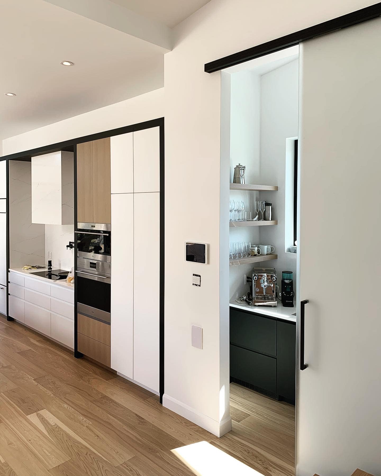 Une cuisine avec des portes coulissantes en verre menant à un garde-manger