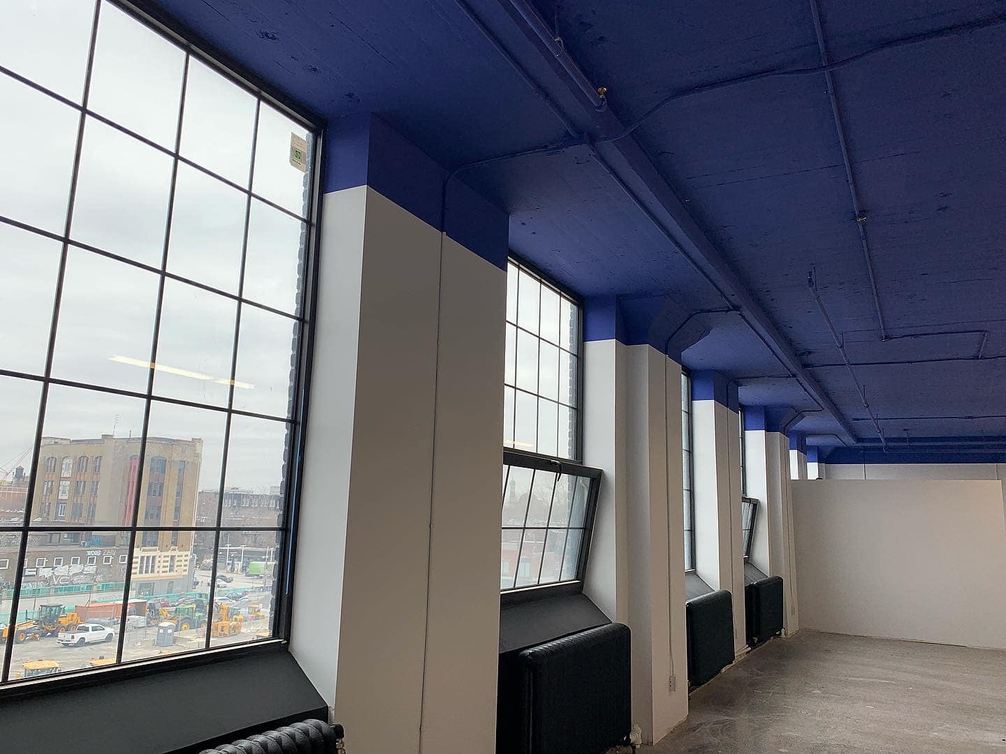 Une pièce avec un plafond bleu et beaucoup de fenêtres