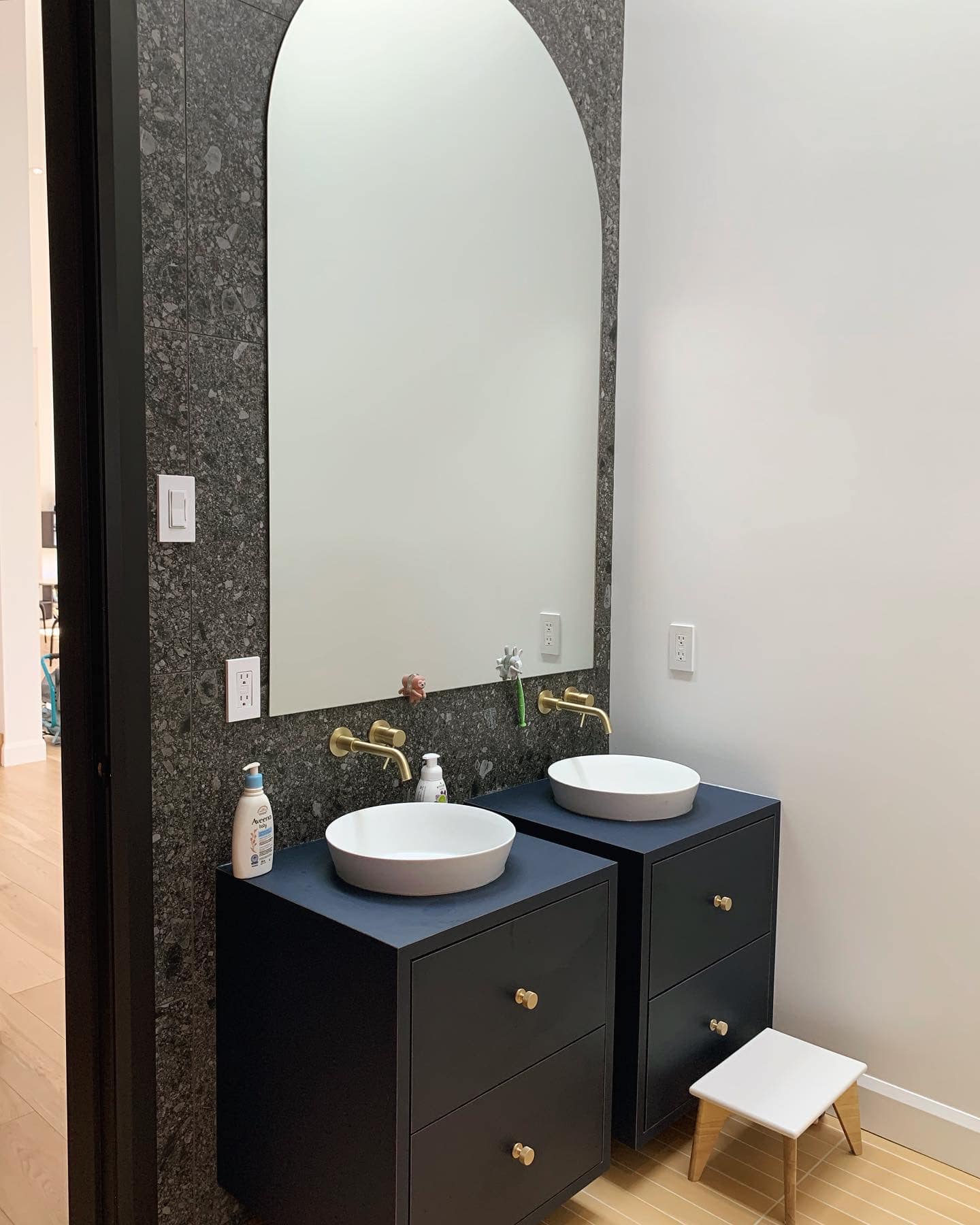 Une salle de bain avec deux lavabos et un grand miroir.