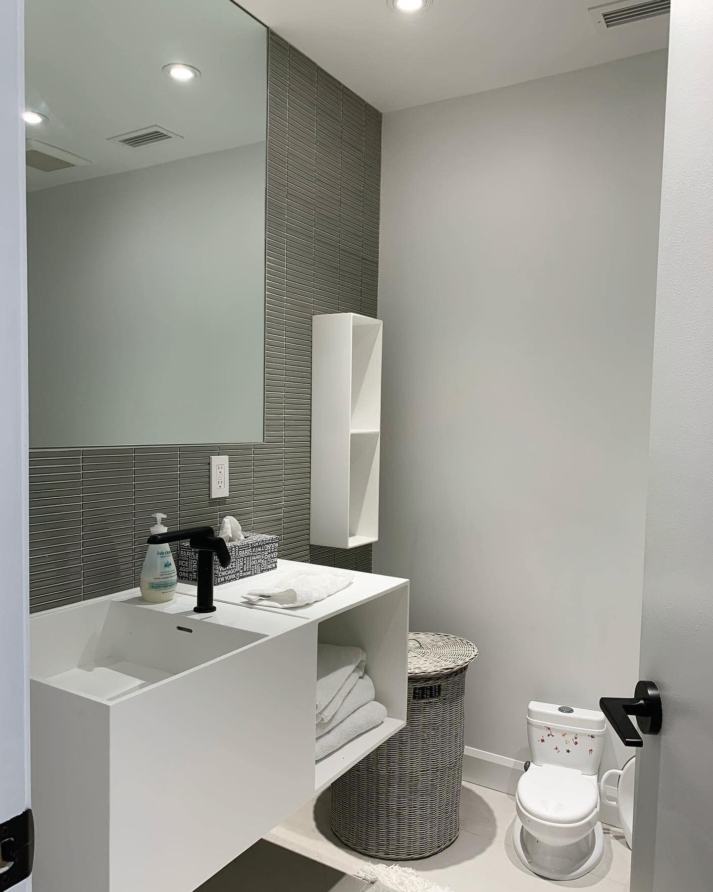 Une salle de bain avec lavabo, toilettes et miroir