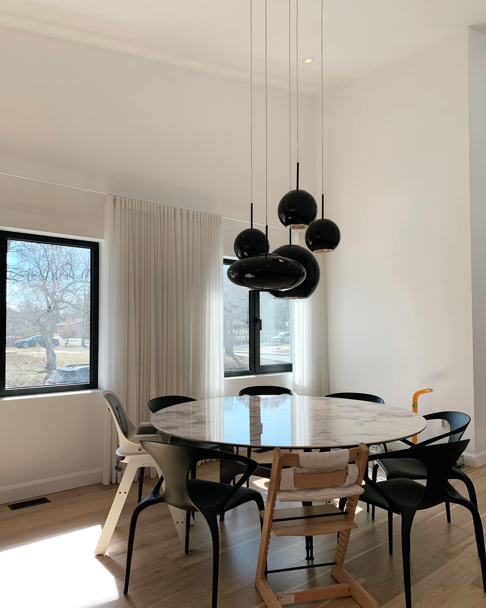 Une salle à manger avec une table ronde et des chaises et une fenêtre.