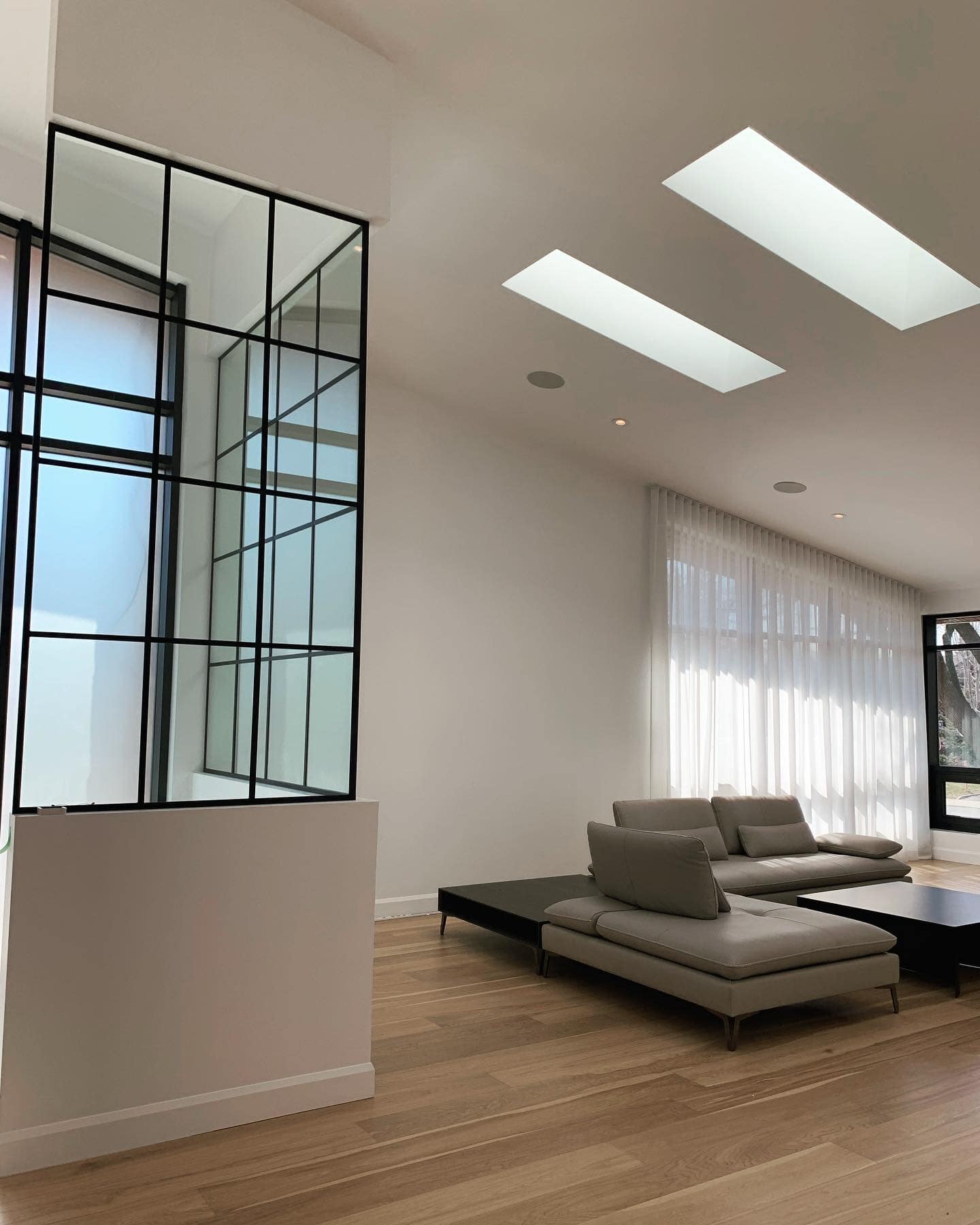 Un salon avec un canapé, une table et des puits de lumière.