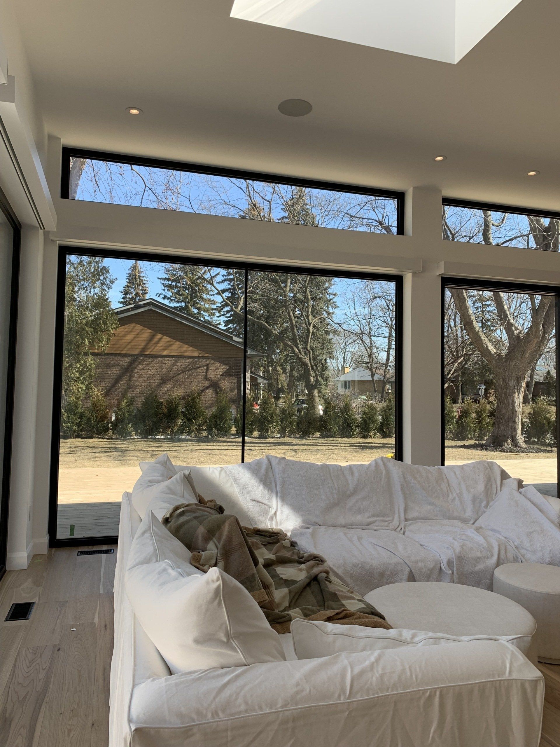 Un salon avec un canapé sectionnel blanc et de grandes fenêtres