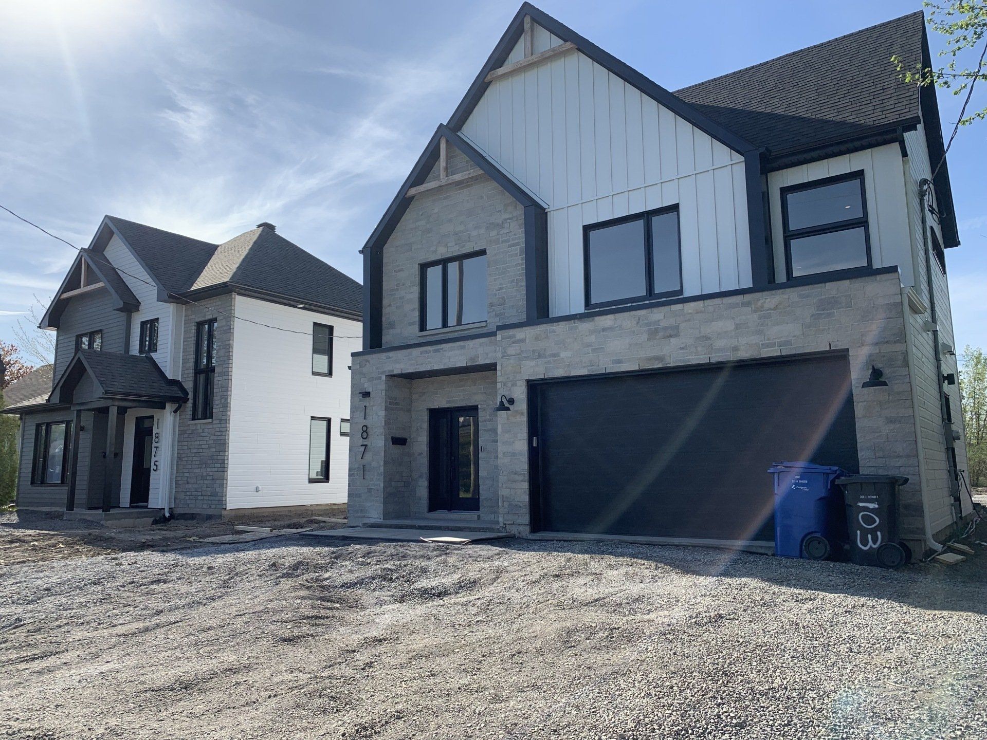 Deux maisons sont situées l'une à côté de l'autre sur un chemin de gravier.