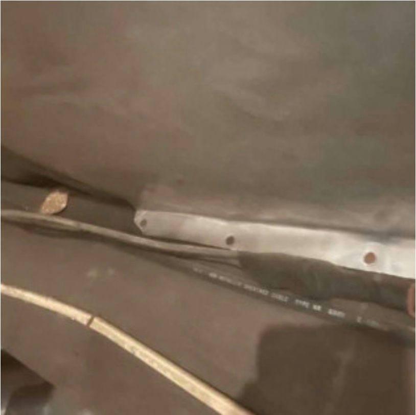 A close up of a metal bracket on a black surface.