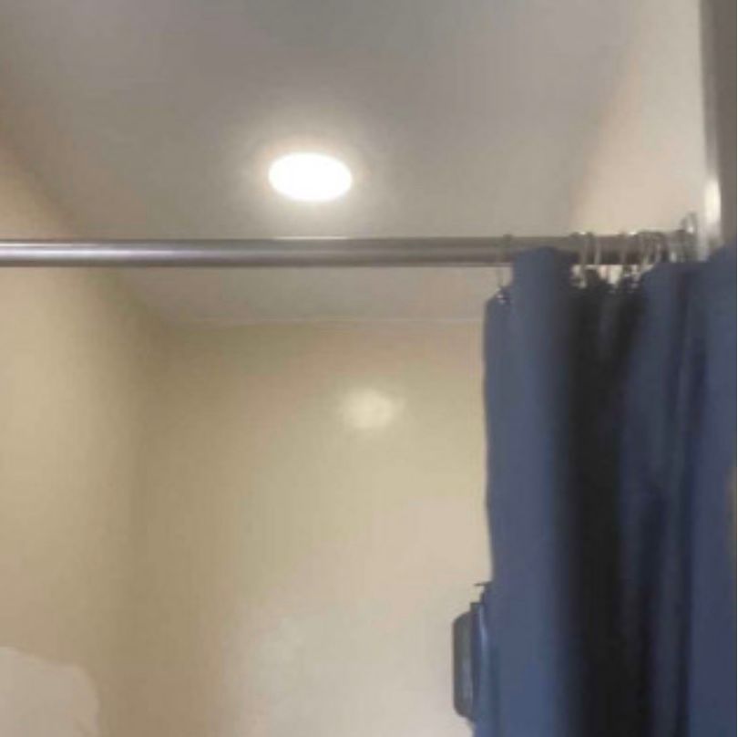 A shower curtain is hanging from a shower rod in a bathroom.