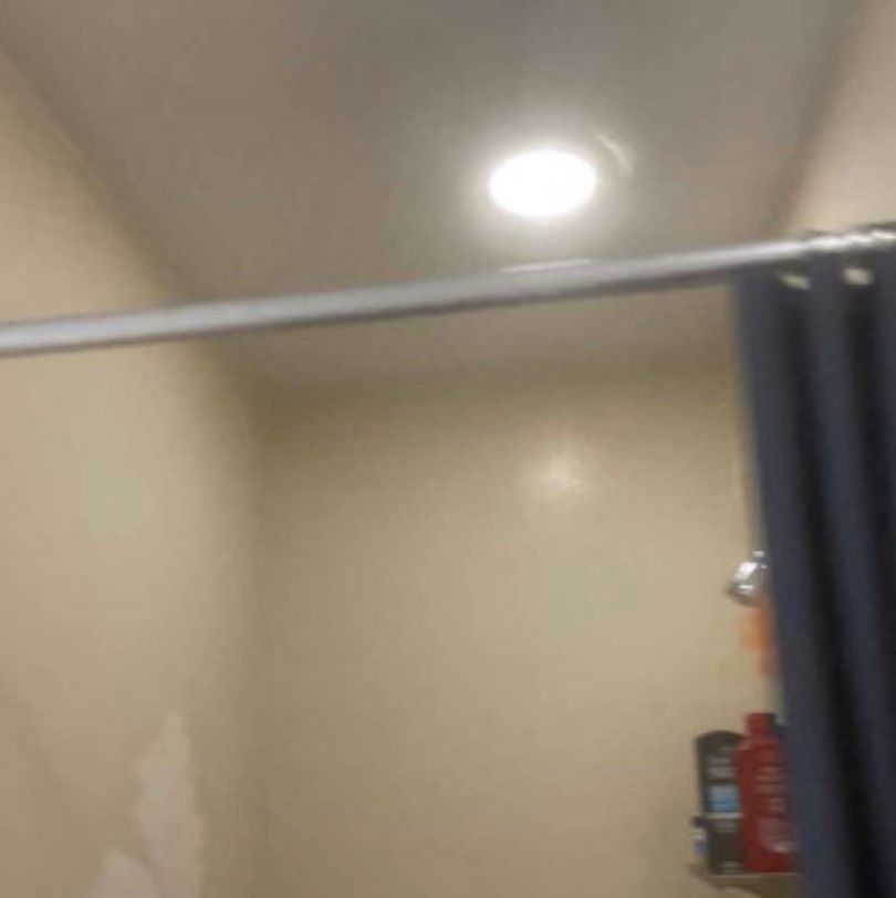A bathroom with a shower curtain and a light on the ceiling.