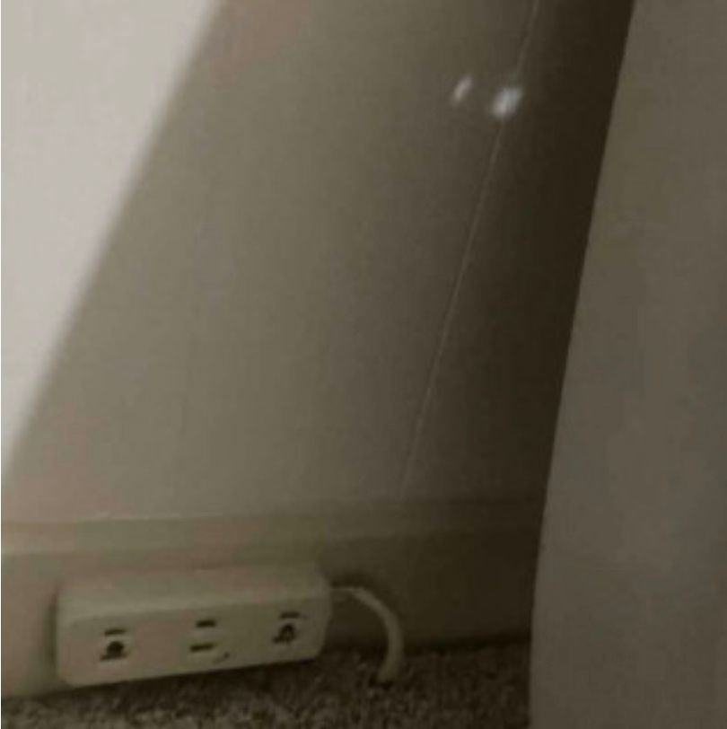 A white electrical outlet is plugged into a wall.