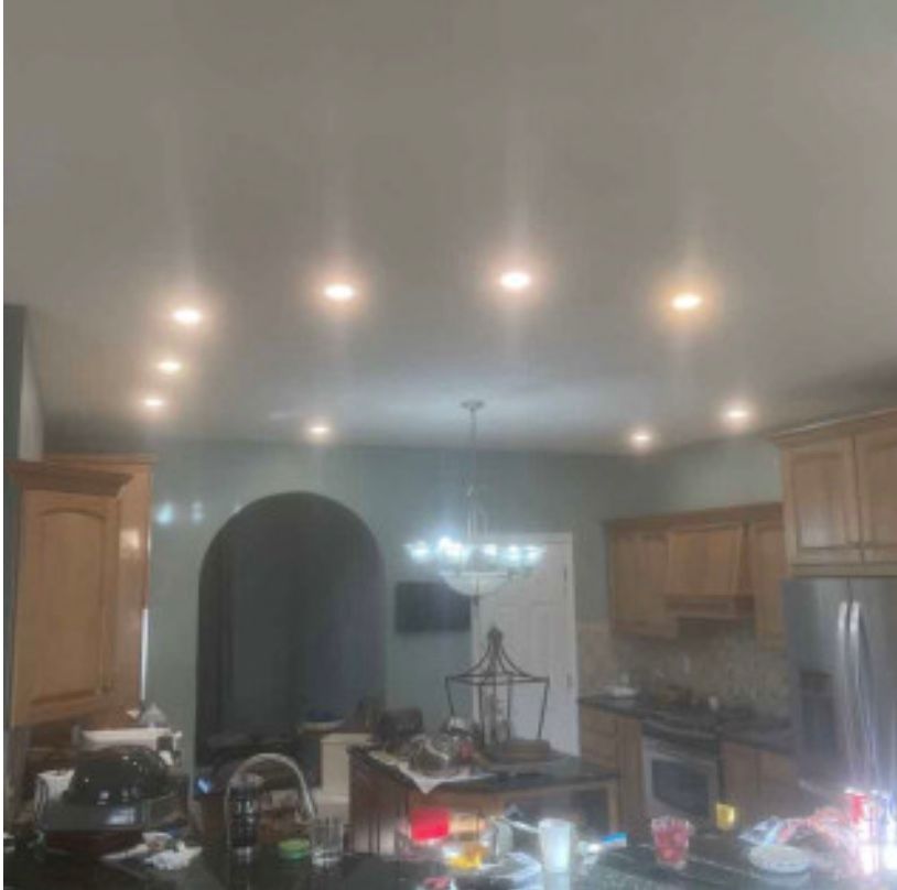 A kitchen with a lot of lights on the ceiling.