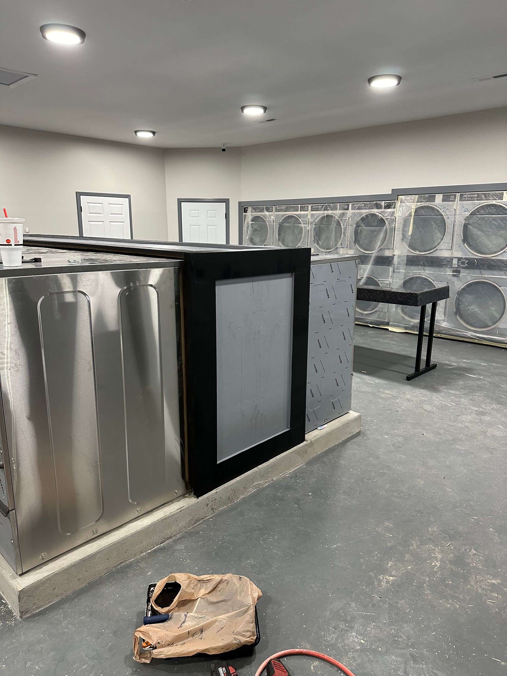 A laundromat with a lot of washing machines and a skull on the floor.