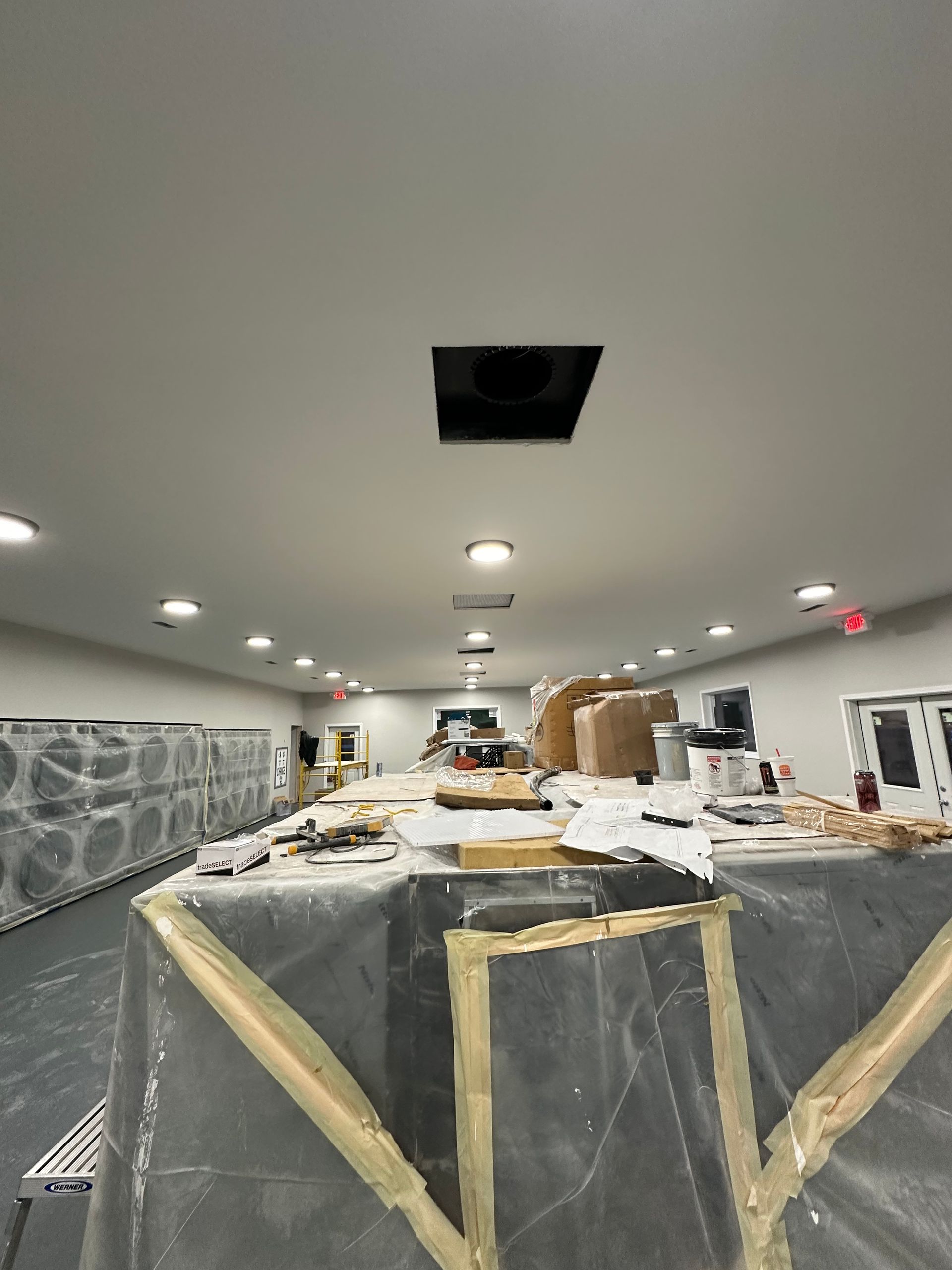 A large room with a lot of boxes on the floor and a hole in the ceiling.