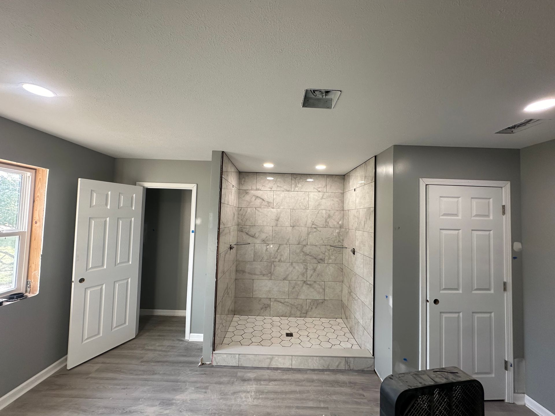 There is a large walk in shower in the middle of the room.