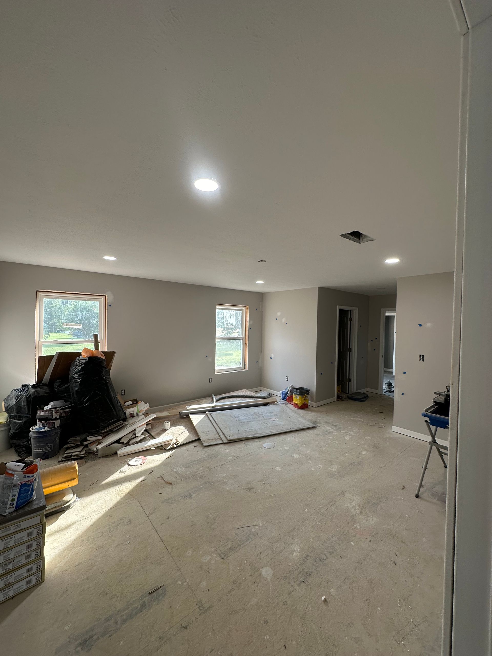 A large room with a lot of furniture in it is being remodeled.