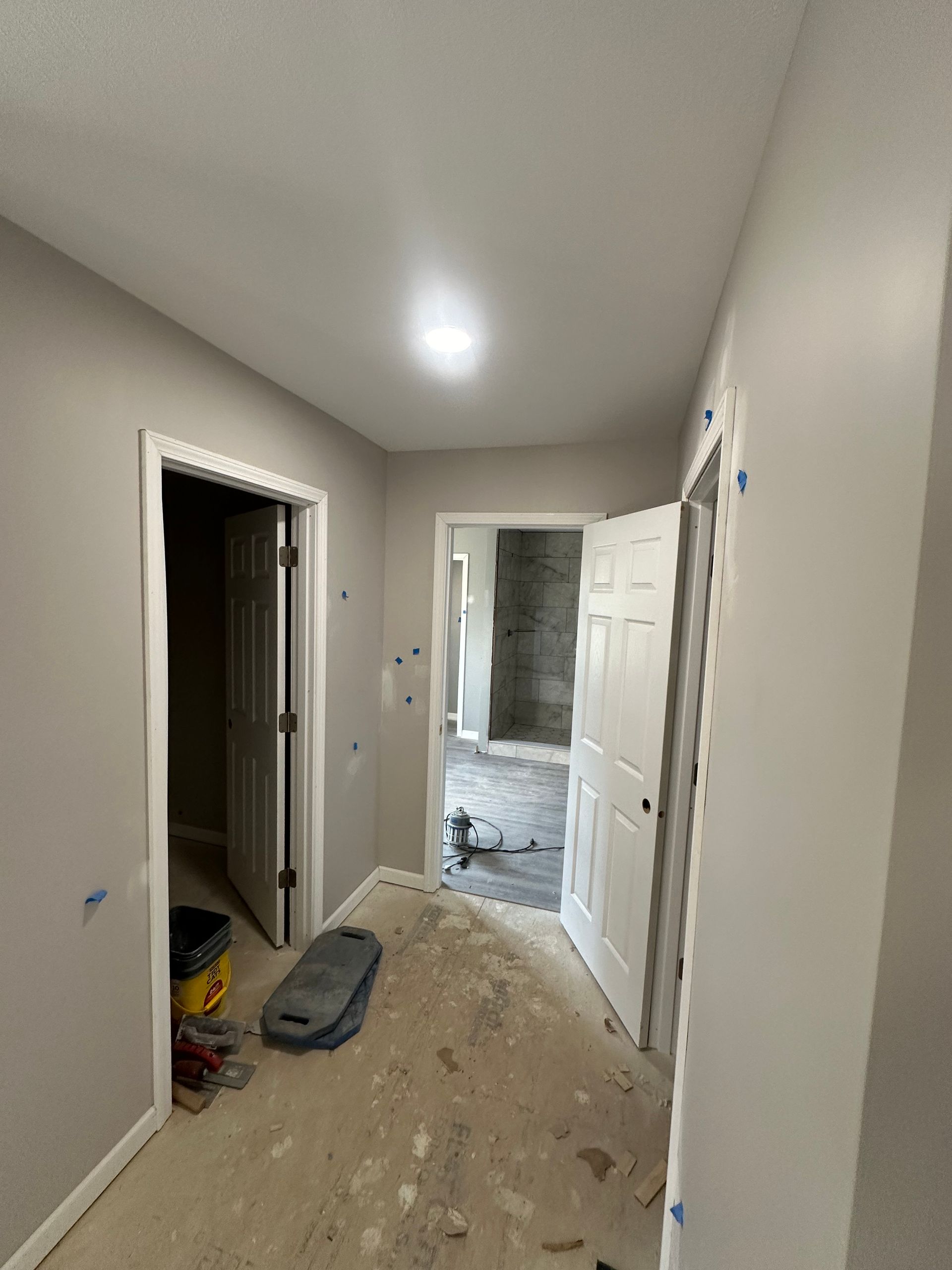 A hallway in a house under construction with a vacuum cleaner on the floor.