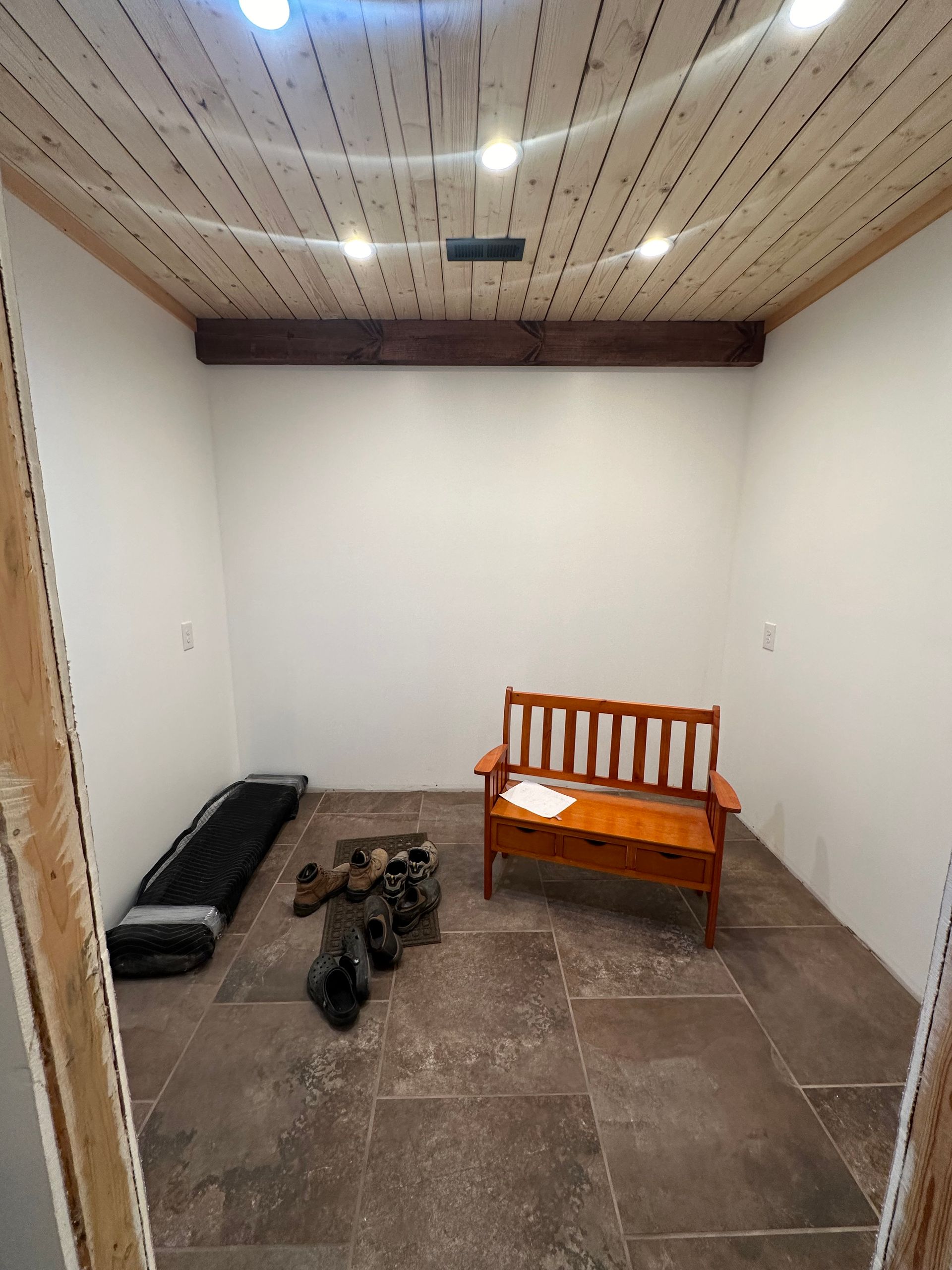 A room with a bench and a table in it.