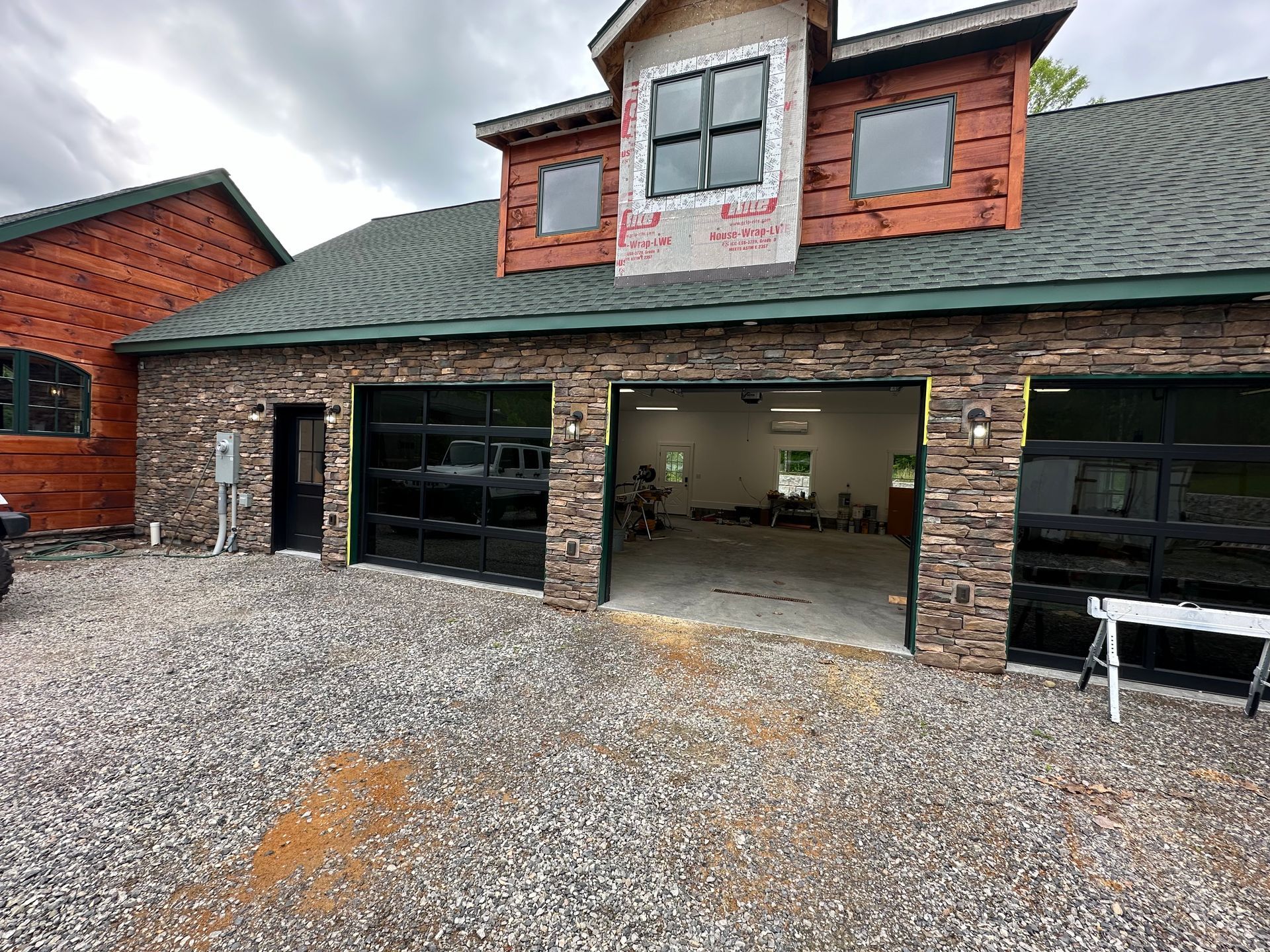A large house with a garage and a car parked in front of it.