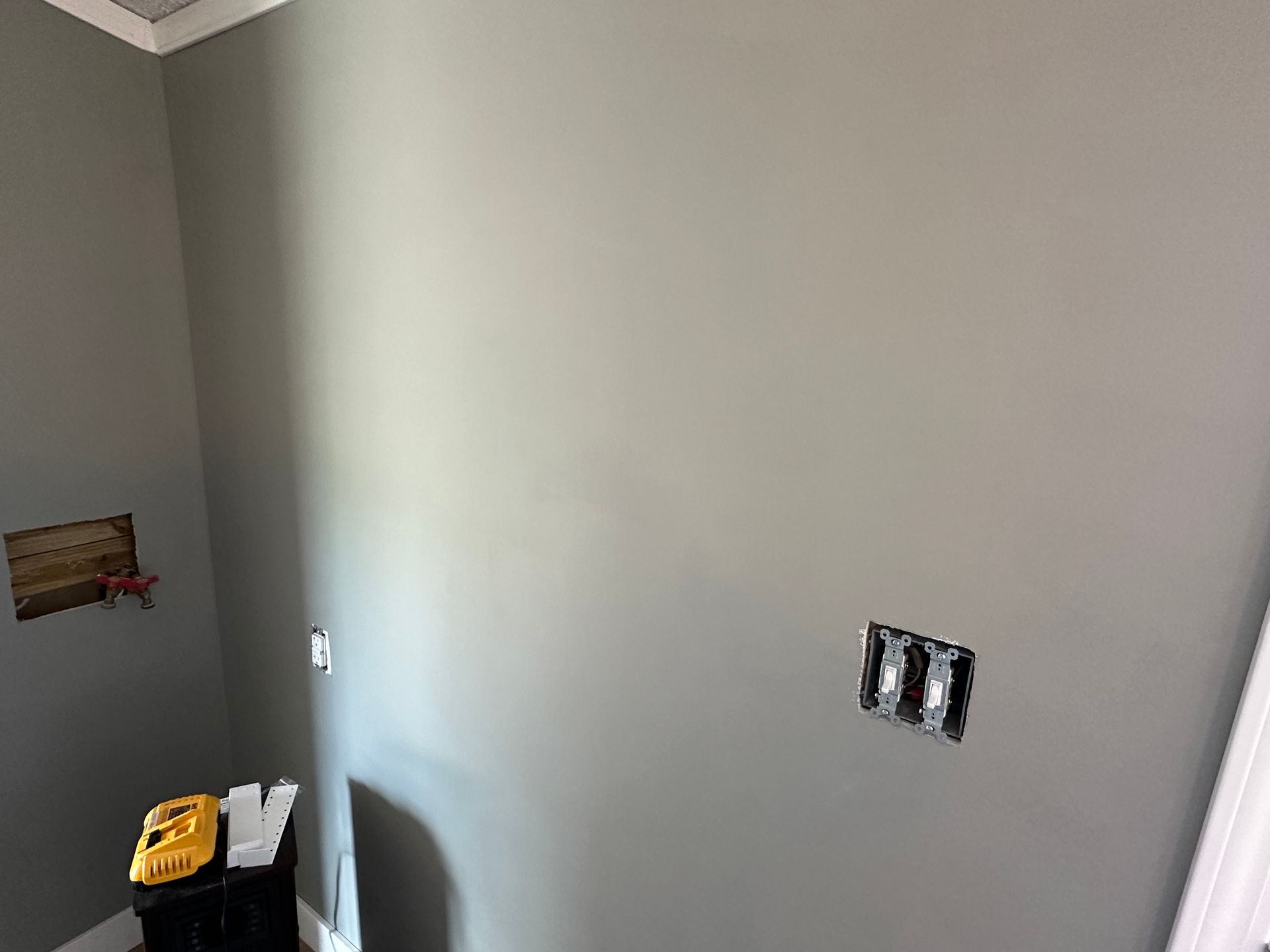 A room with gray walls and a black box on the wall.