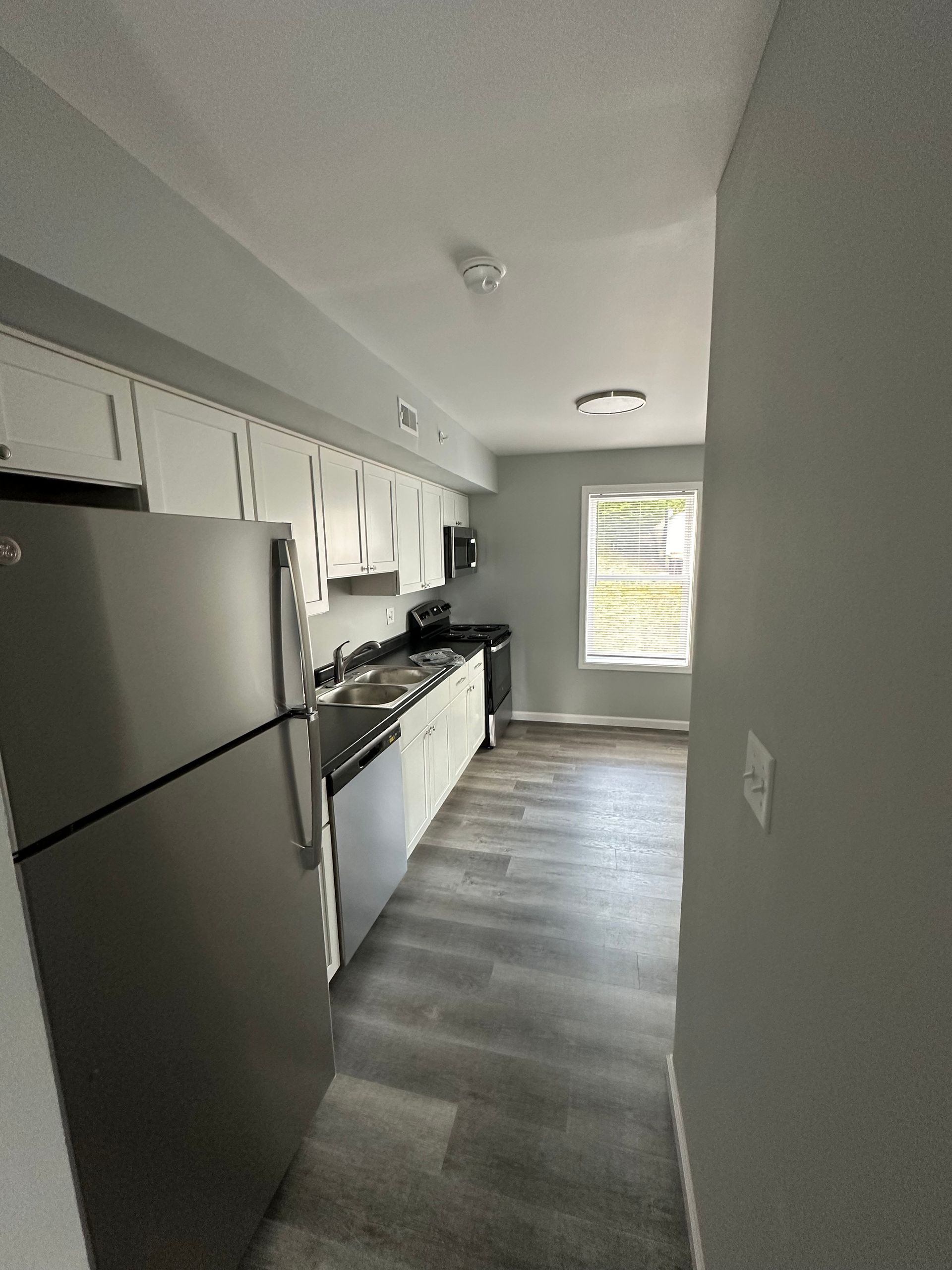 A kitchen with stainless steel appliances and white cabinets