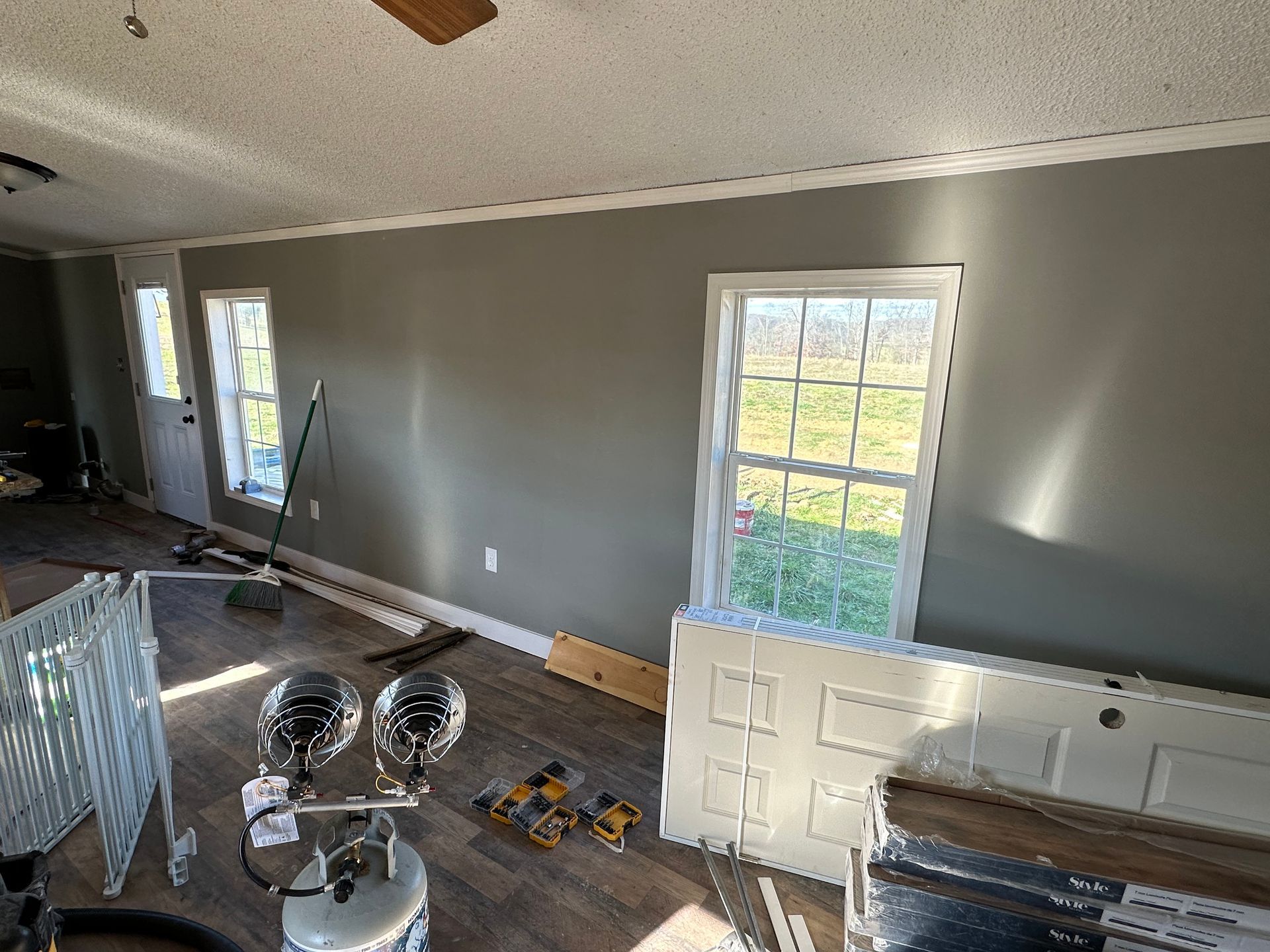 A living room with a lot of windows and a ceiling fan.