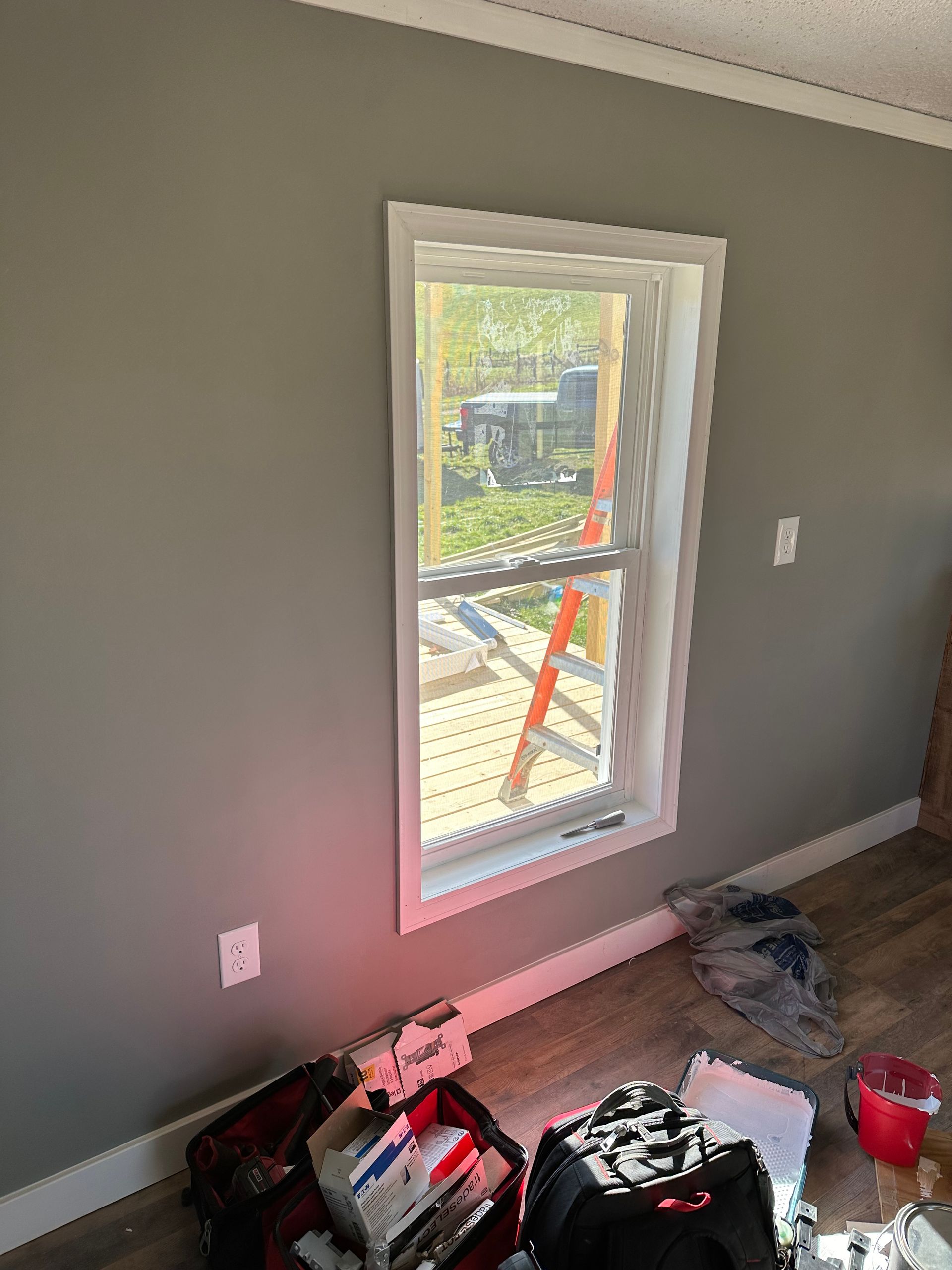 A room with a window and a scaffolding in the background.