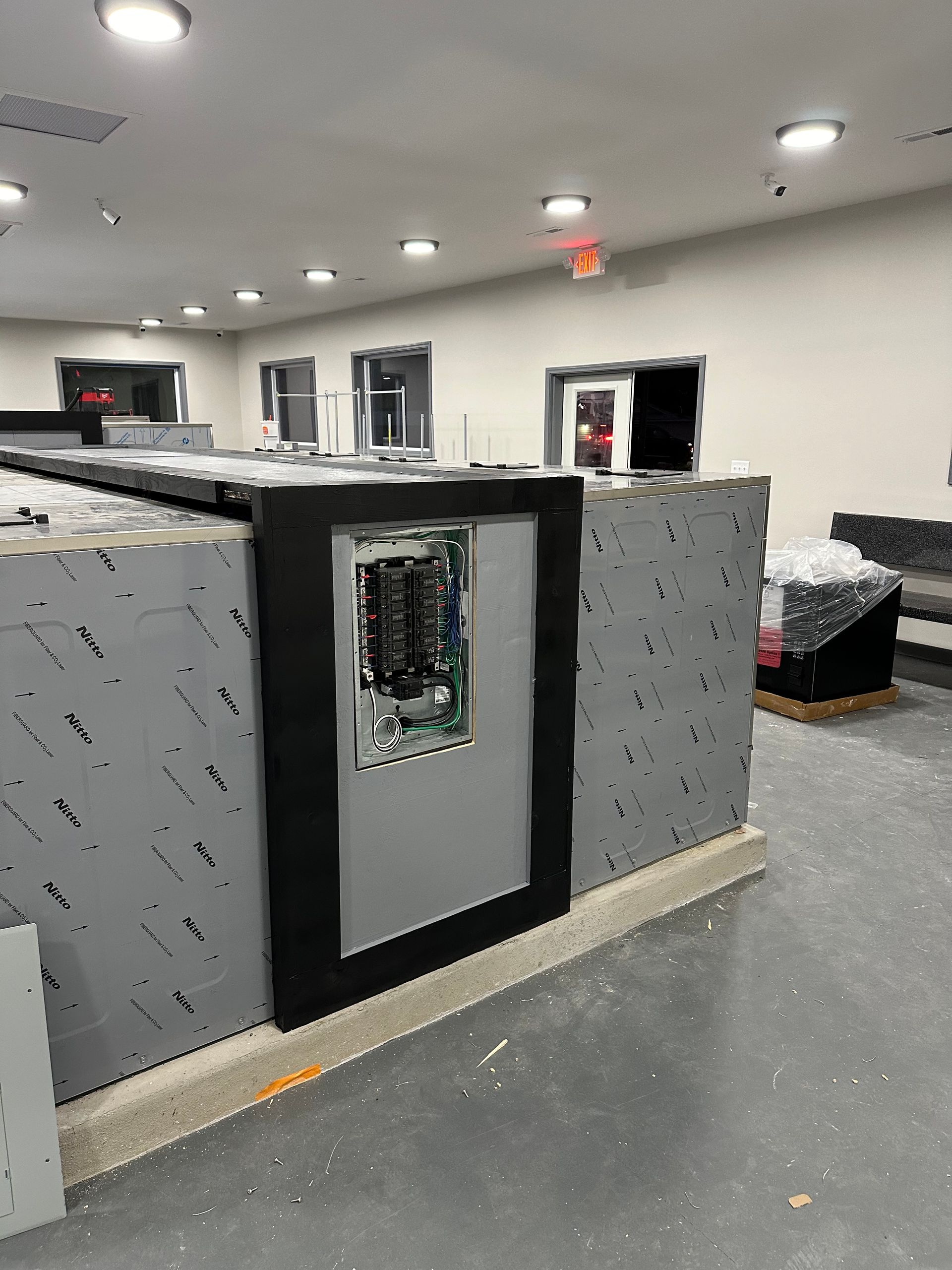 A room with a gray wall and a black door