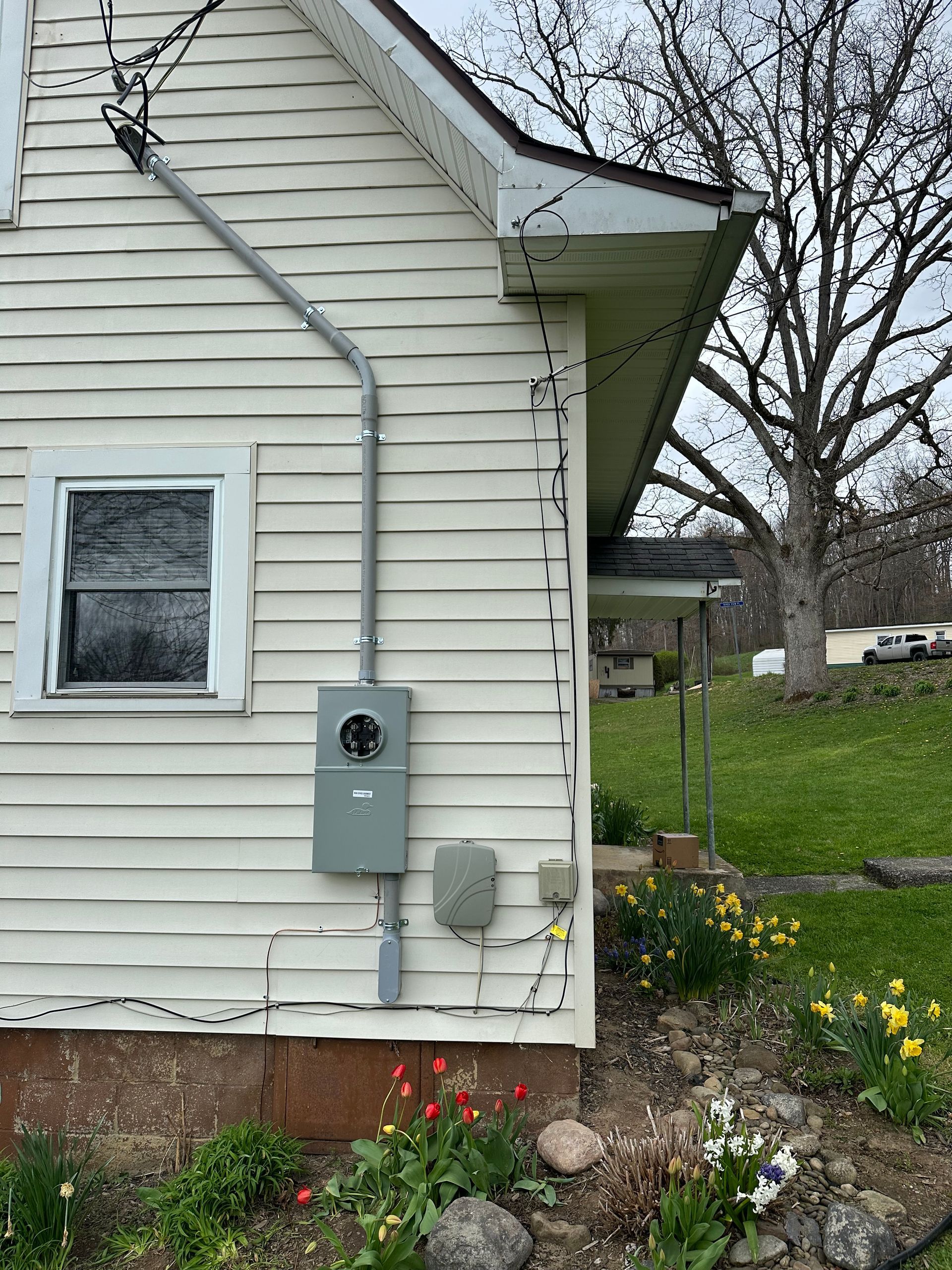 A white house with a electrical box on the side of it.
