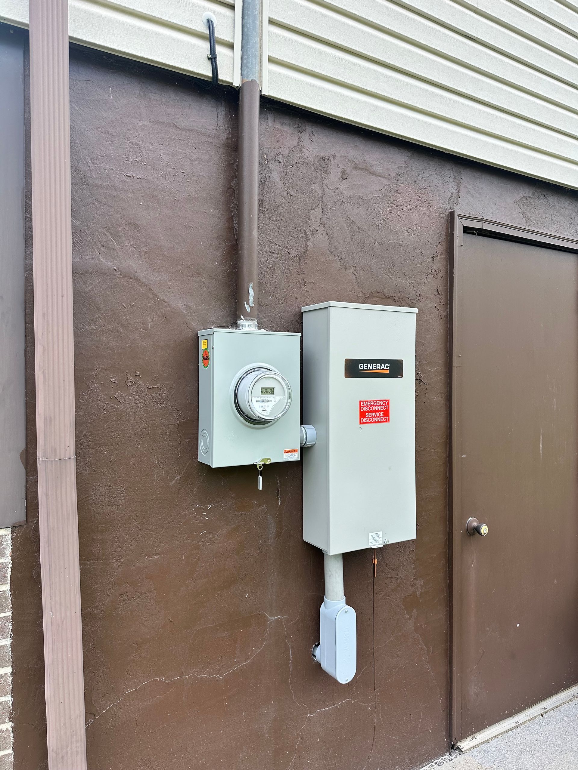 An electrical box on the side of a building next to a door