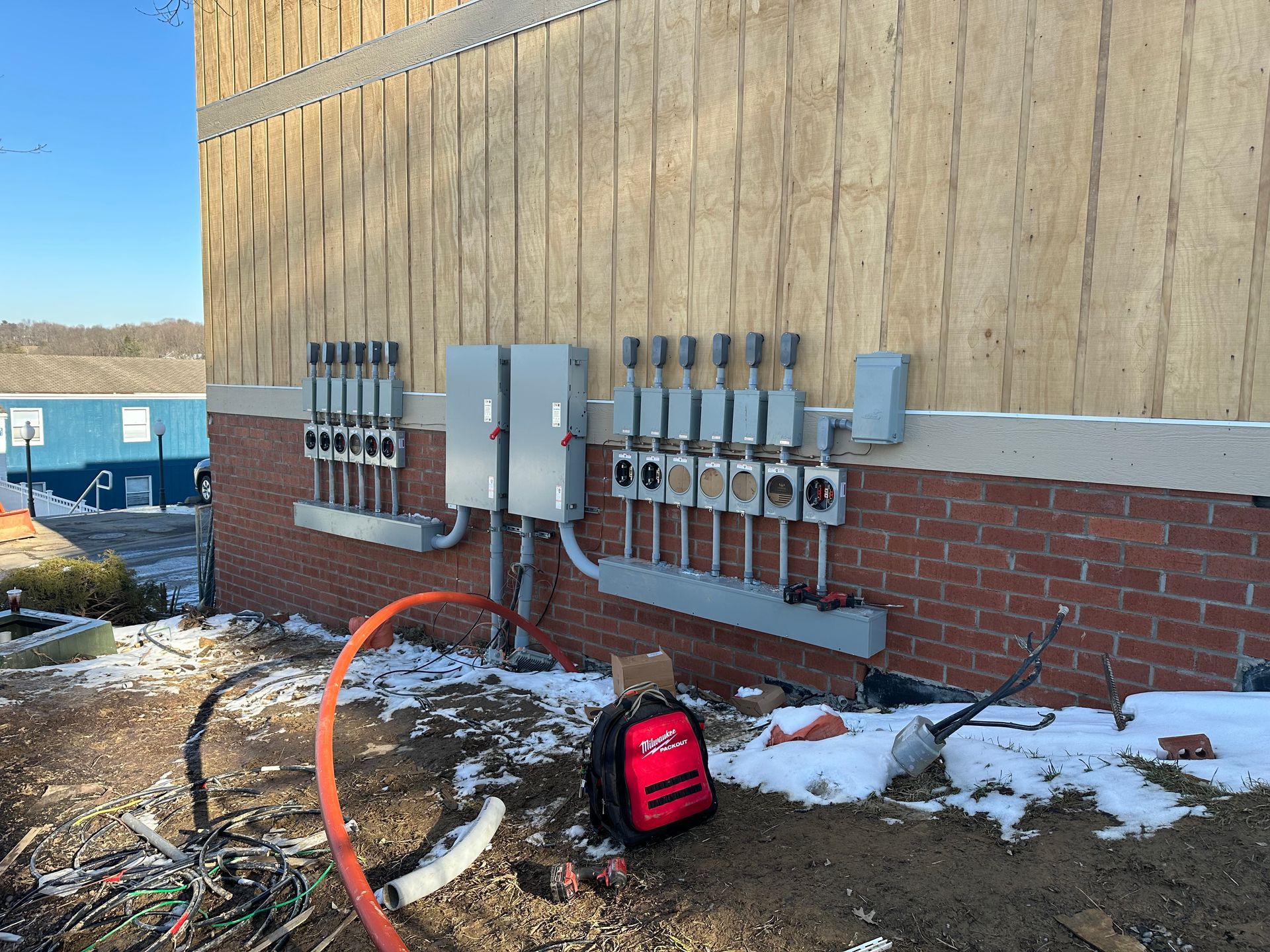 A red bag is sitting on the ground in front of a building.