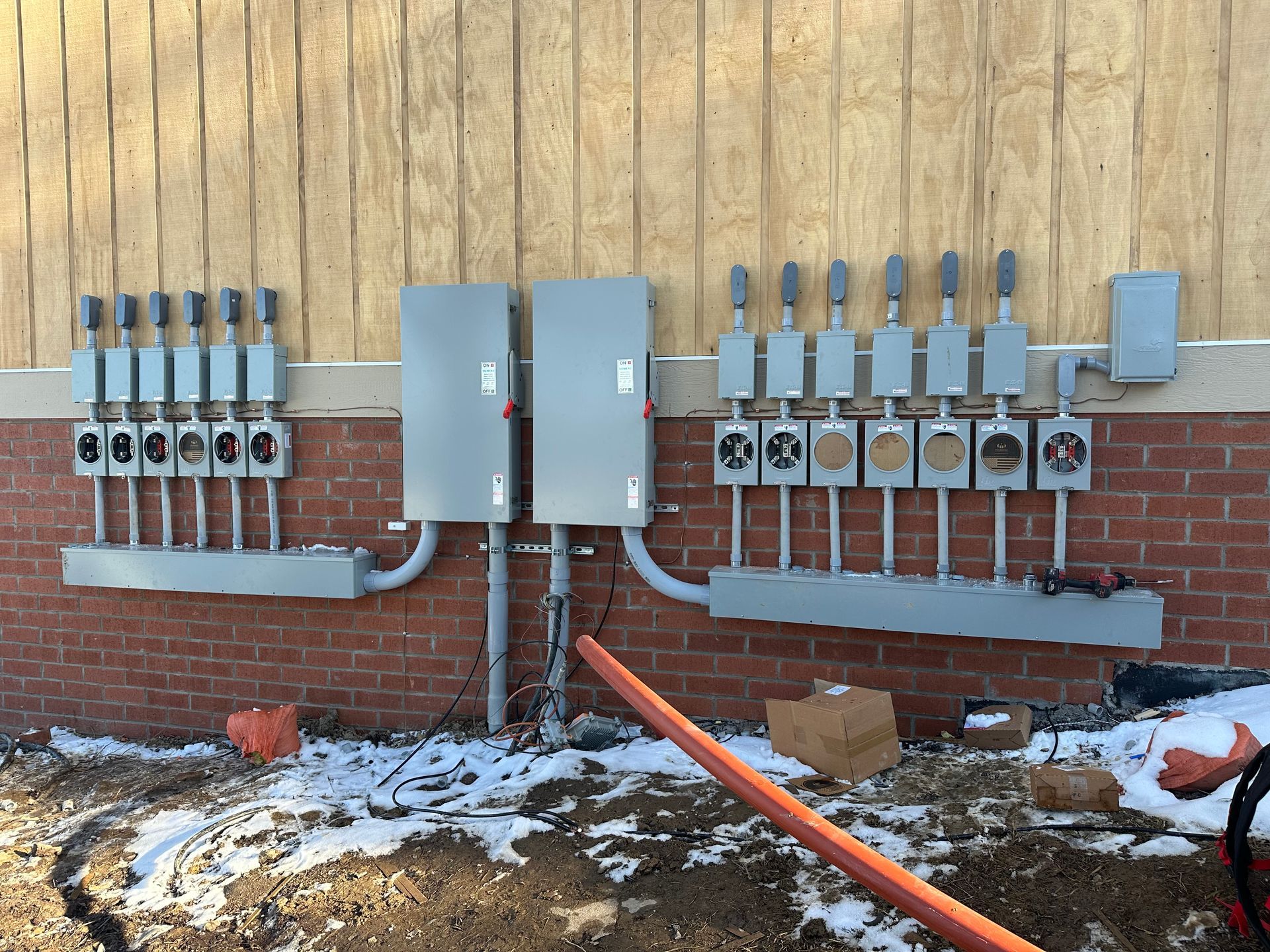 A brick wall with a bunch of electrical boxes on it