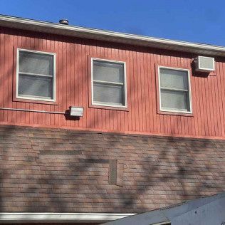 A red building with white windows and a blue sky in the background
