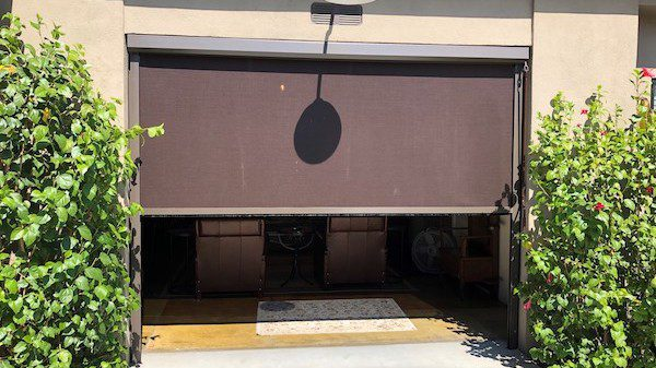 A garage door with a shadow of a pot on it.