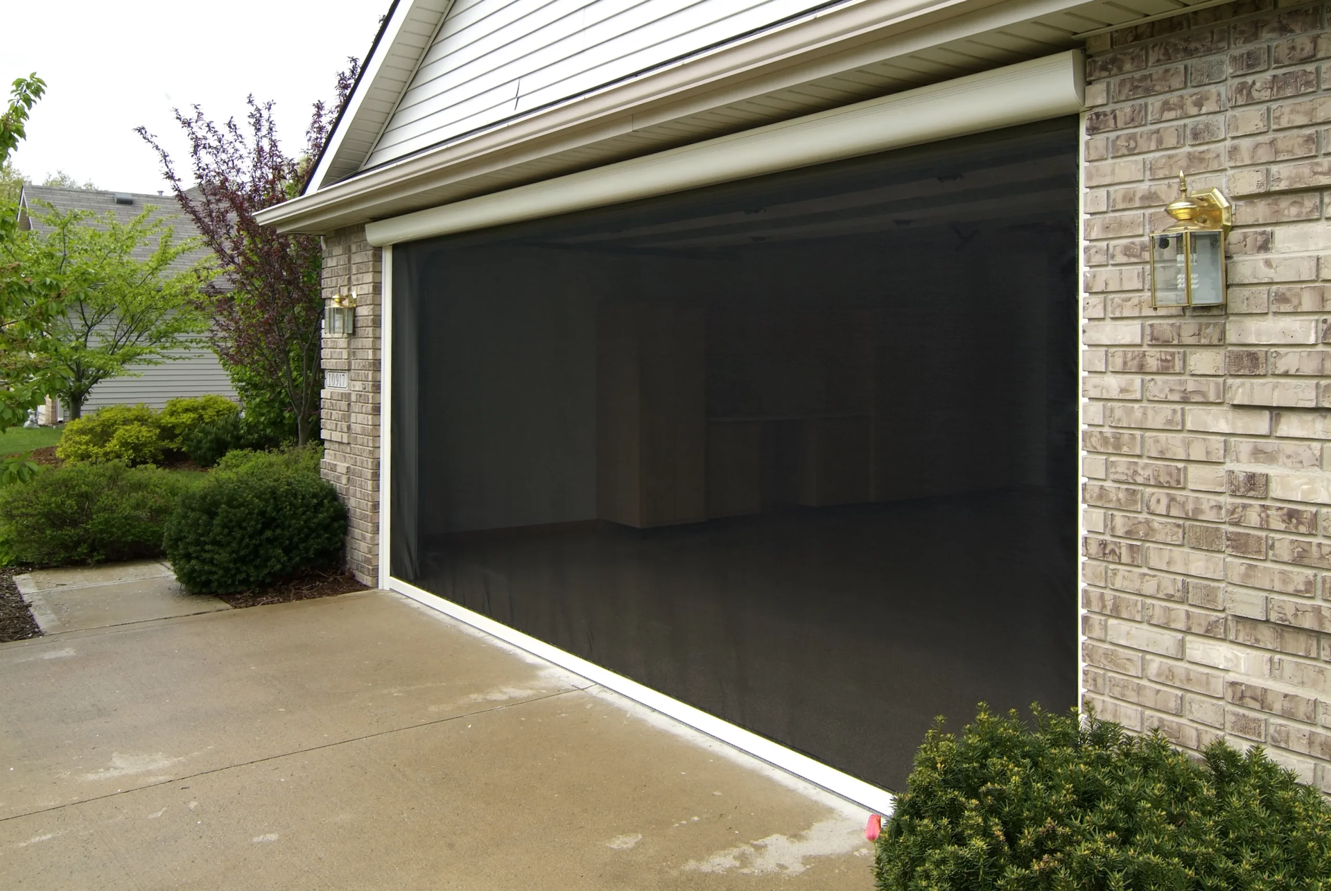 A brick house with a screened in garage door