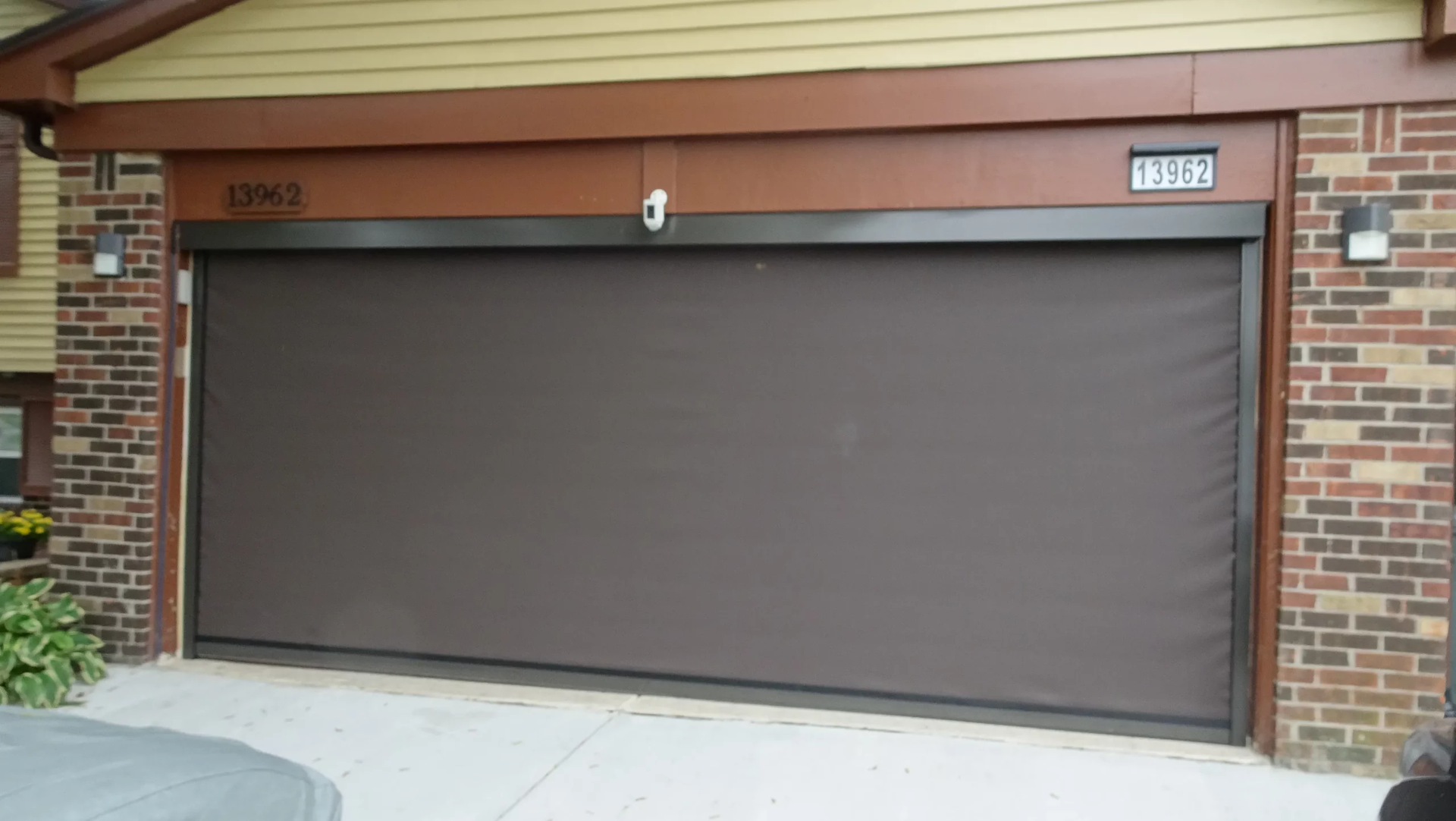 A garage door with a shadow of a pot on it.