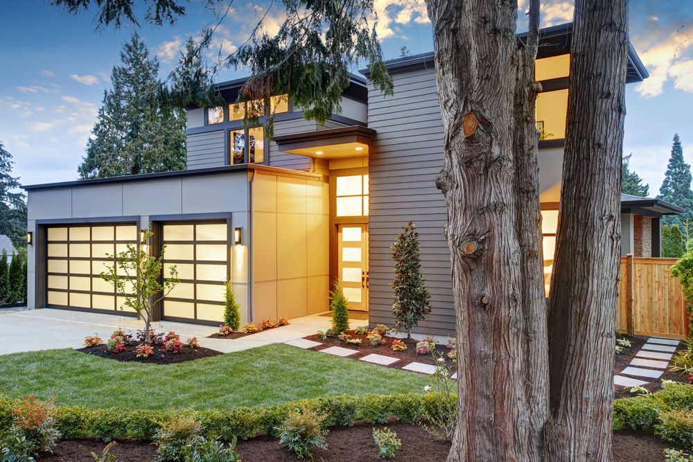 A modern house with a tree in front of it.