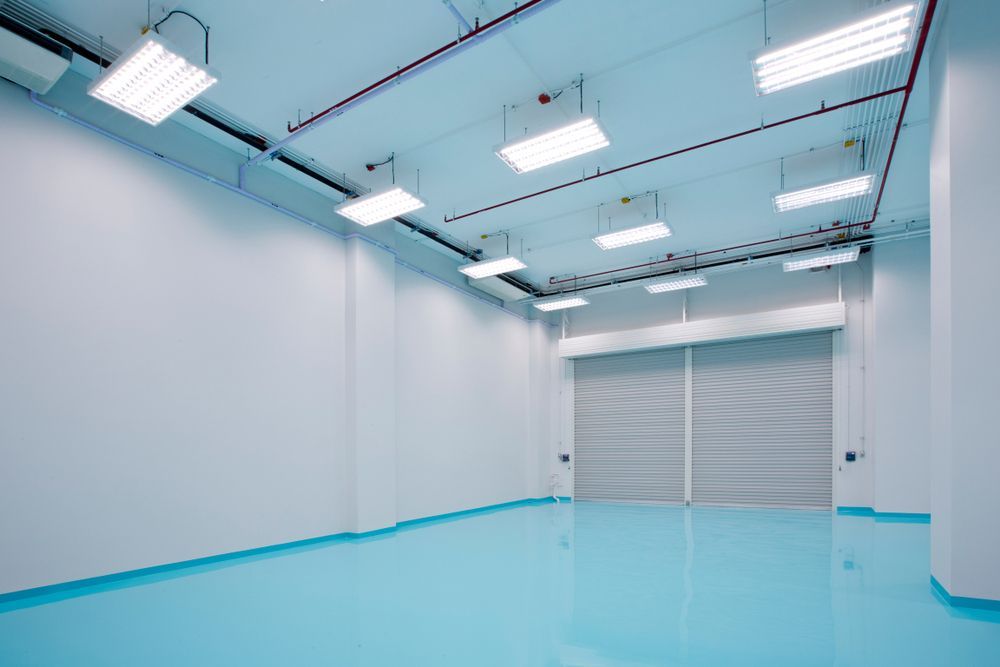 A large empty room with a blue floor and white walls.