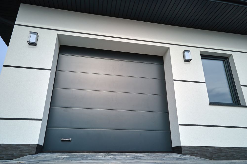 A black garage door is on the side of a house