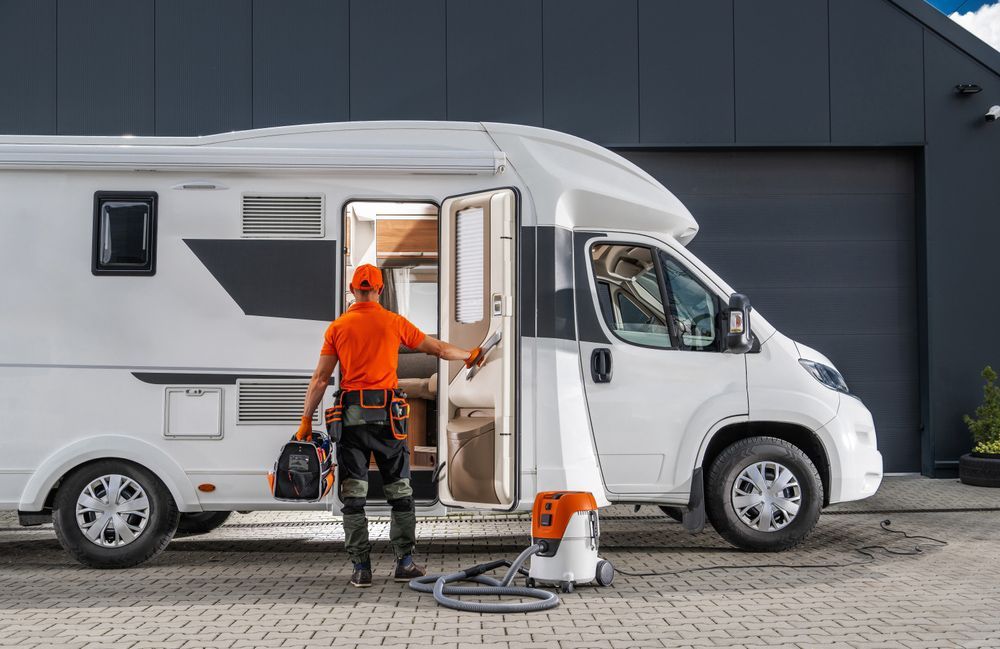 A man is cleaning a rv with a vacuum cleaner.