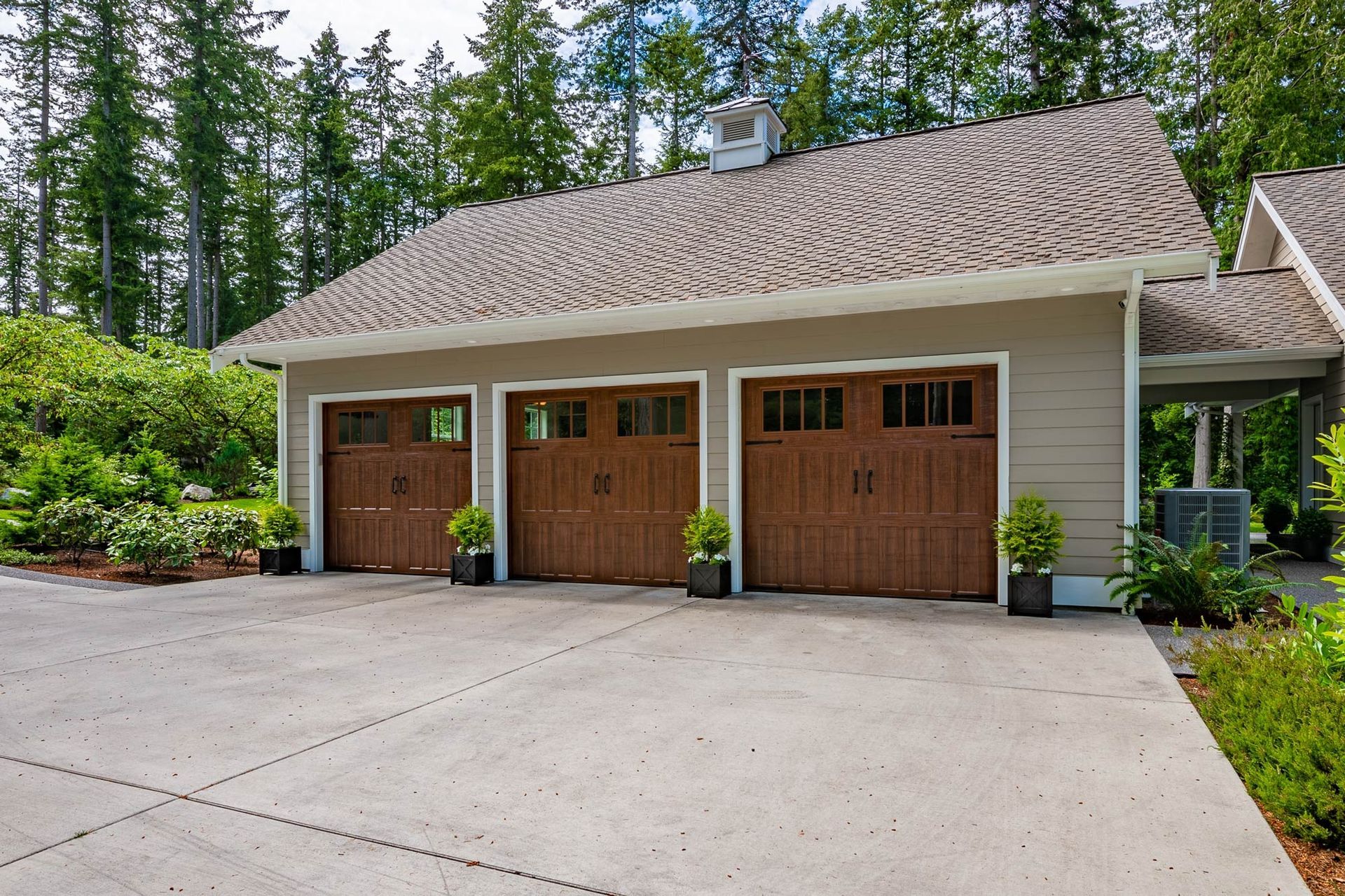 Three garage doors are lined up in front of a house