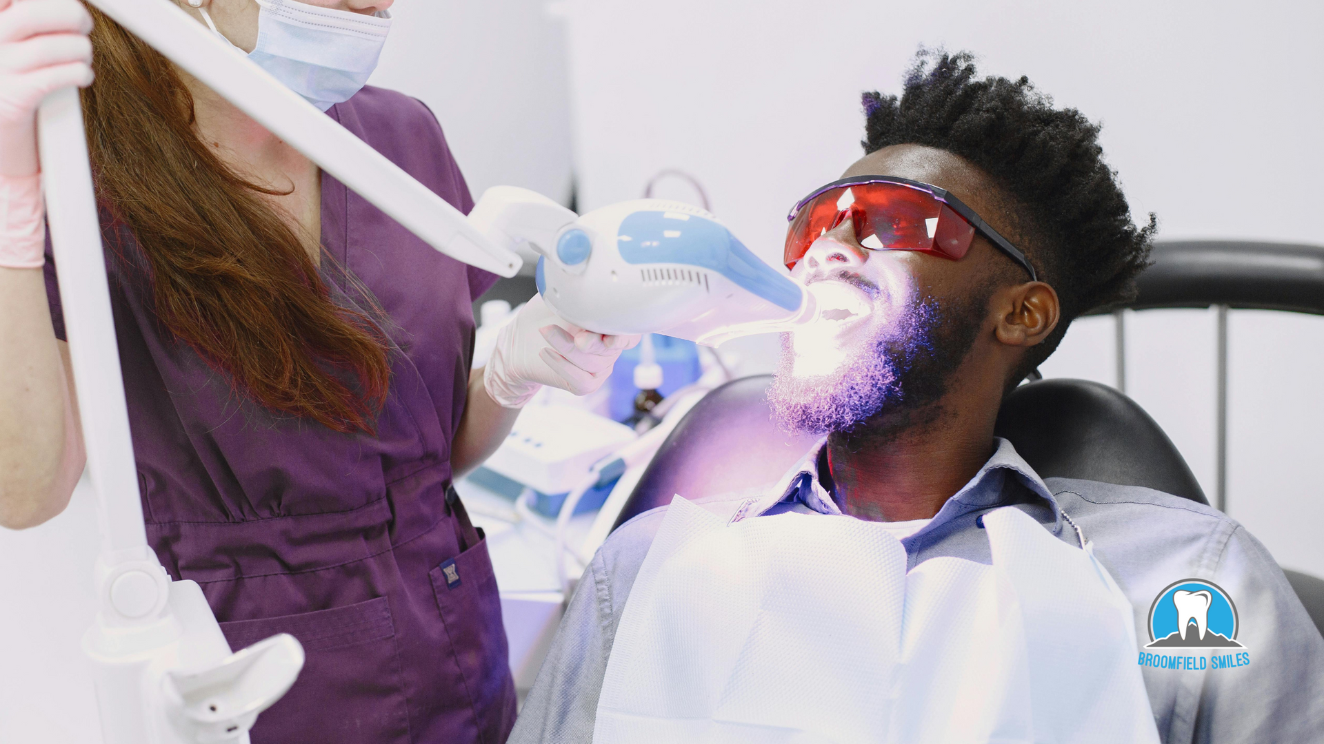A man is getting his teeth whitened by a dentist.