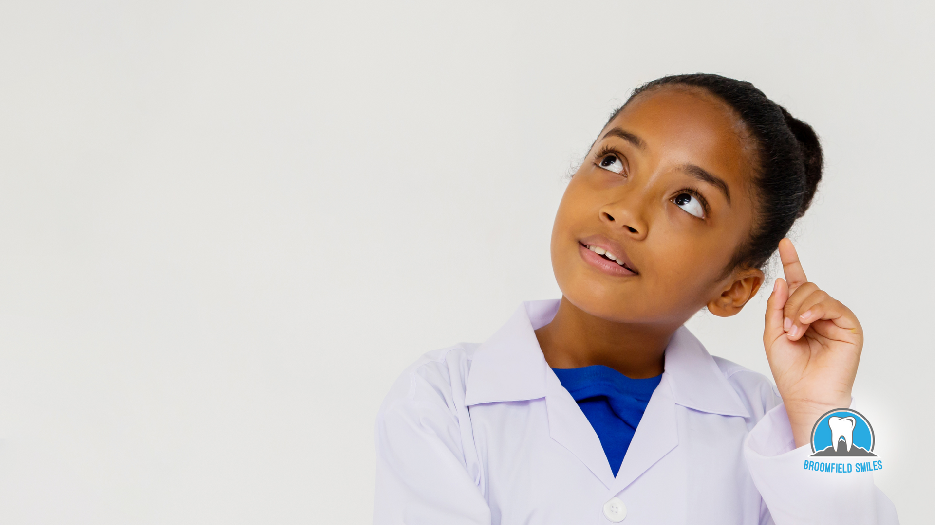 A young girl in a lab coat is thinking and looking up.