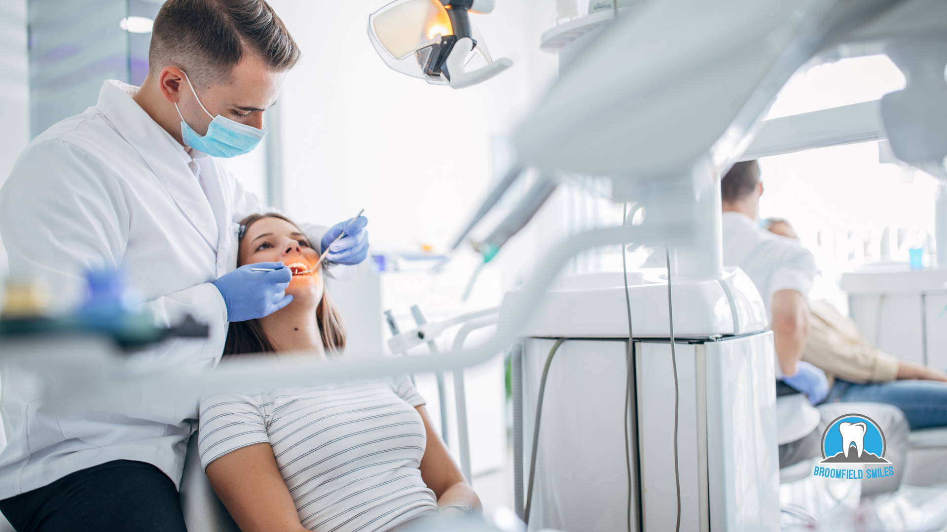 A dentist is examining a woman 's teeth in a dental office.