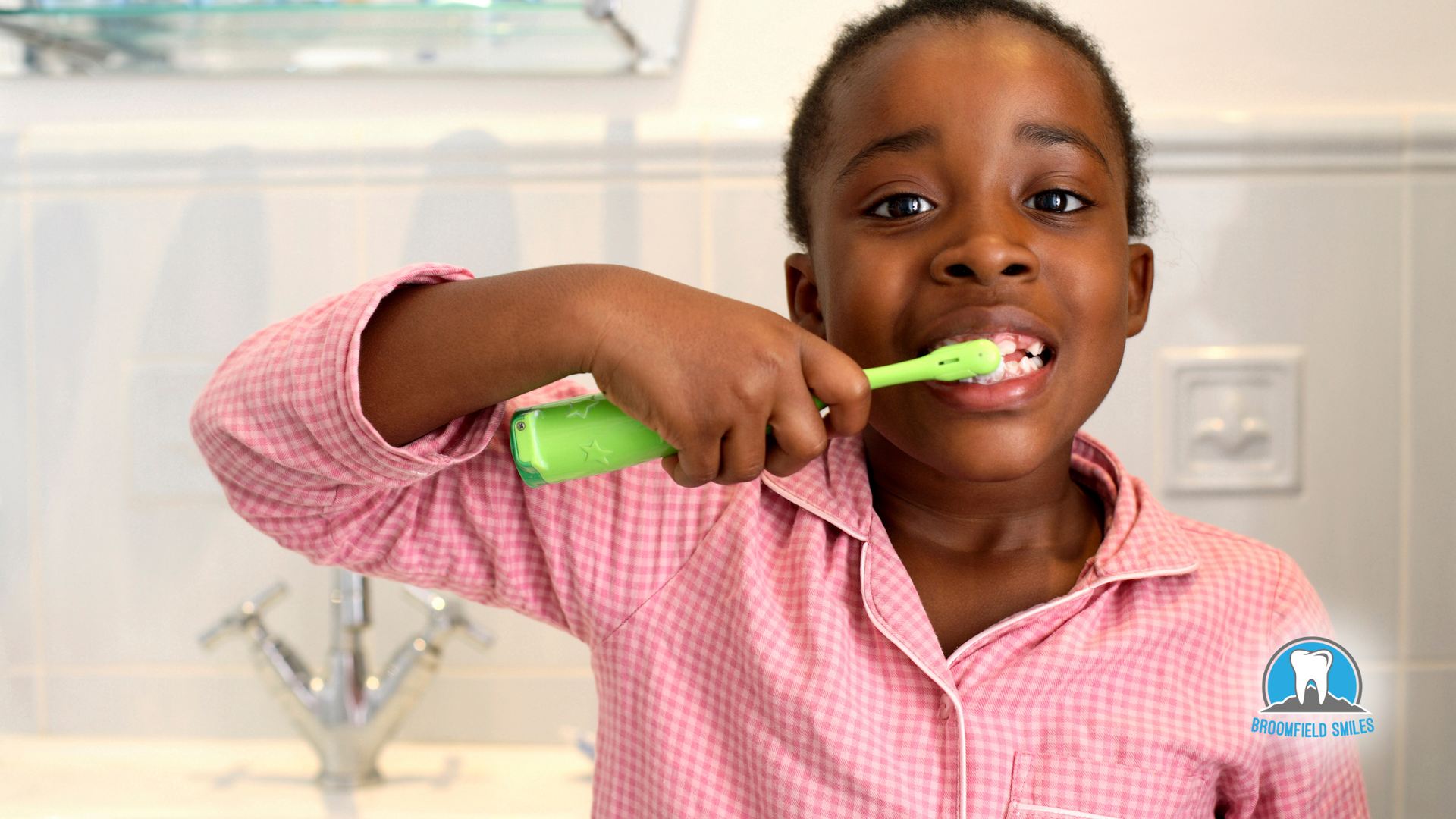 A young boy is brushing his teeth in a bathroom.